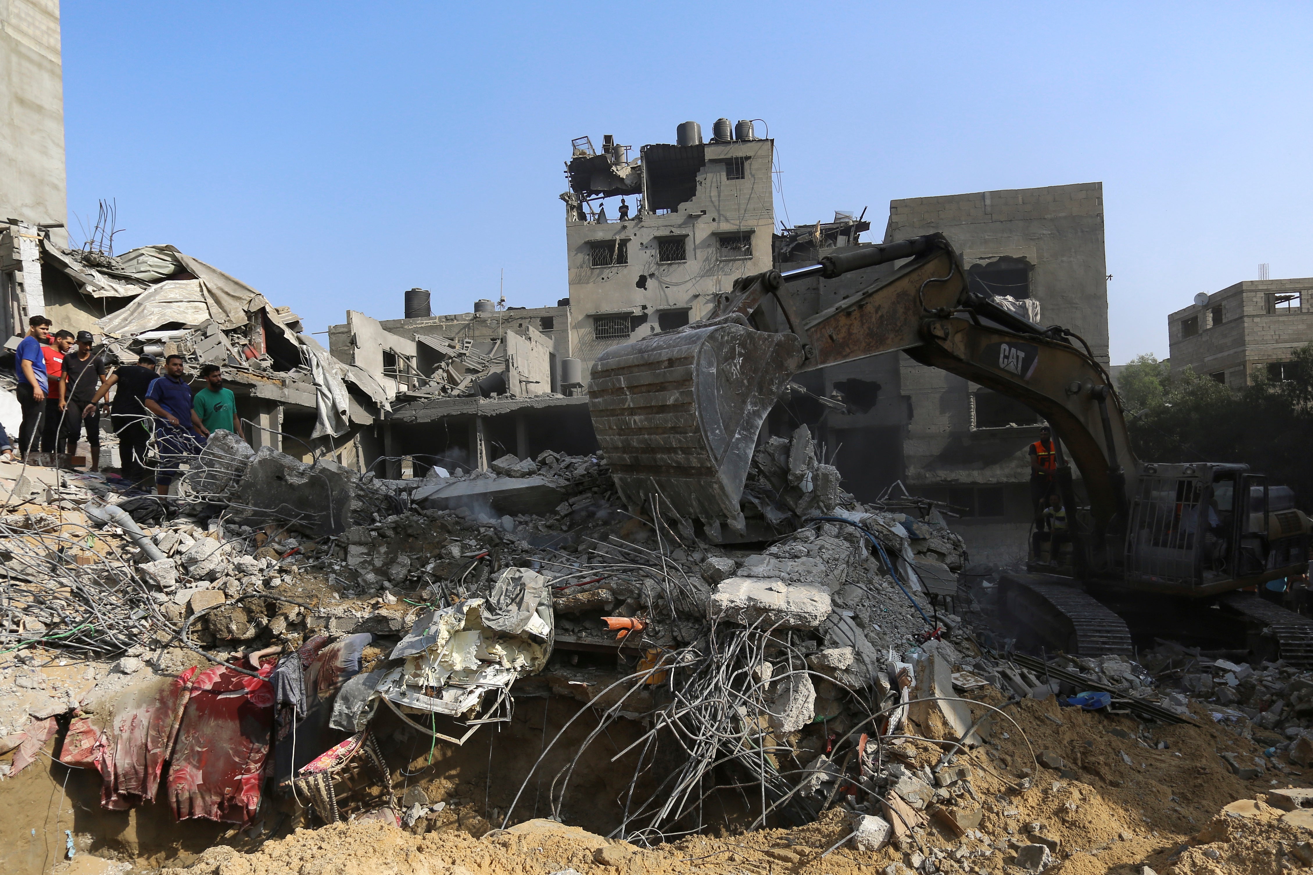 <p>Palestinians inspect the damage of destroyed houses after Israeli airstrikes on Gaza City,</p>