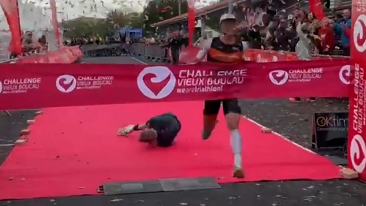 View: Lead triathlete stumbles and tumbles just a few feet away from the end point.
