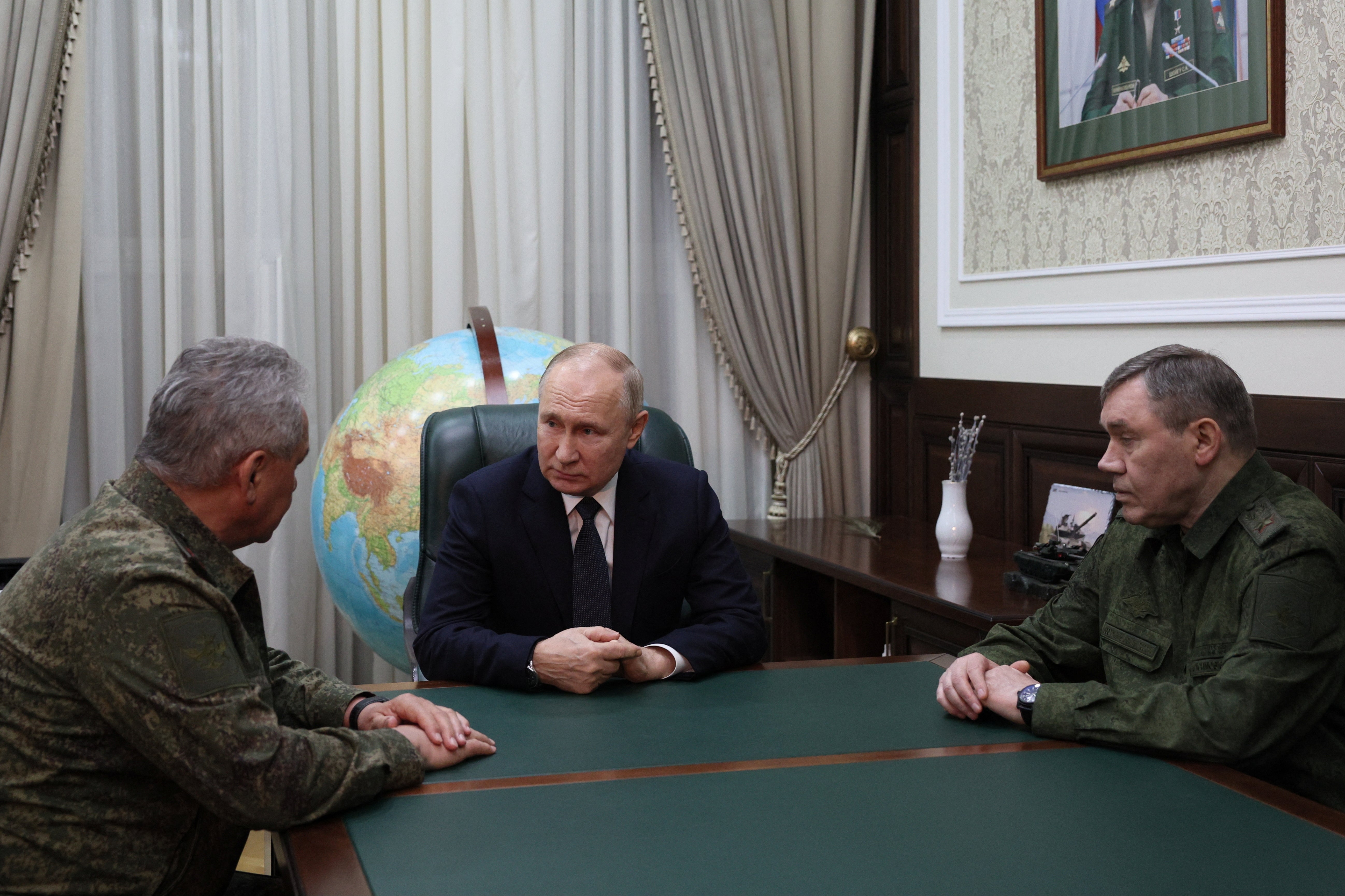 <p>Putin speaks to defence minister Sergei Shoigu (L) and military chief Valery Gerismov (R) in southern Russia </p>