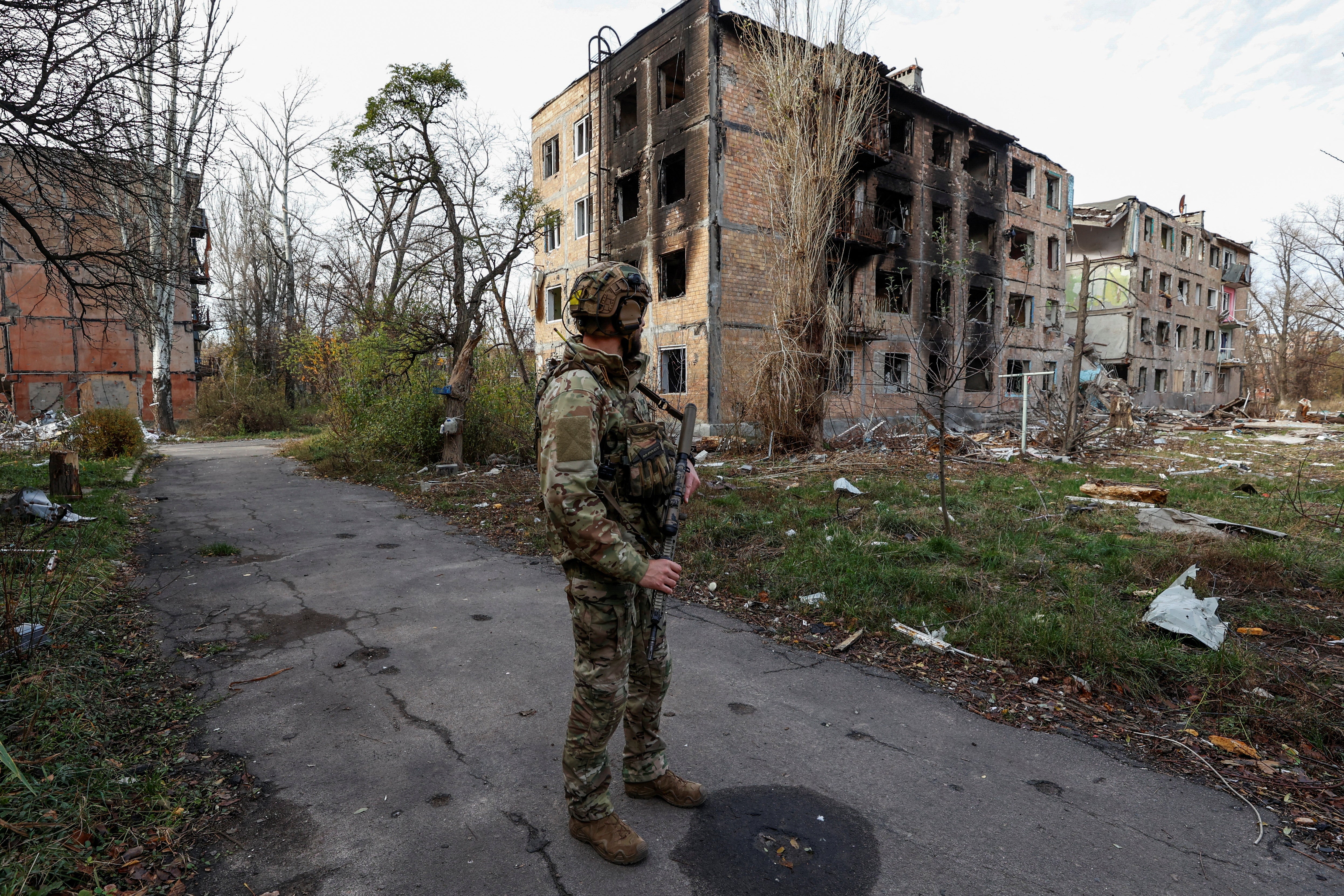 <p>Ukrainian serviceman stands next to residential buildings heavily damaged by permanent Russian military strikes in the front line town of Avdiivka in Donetsk region, Ukraine</p>