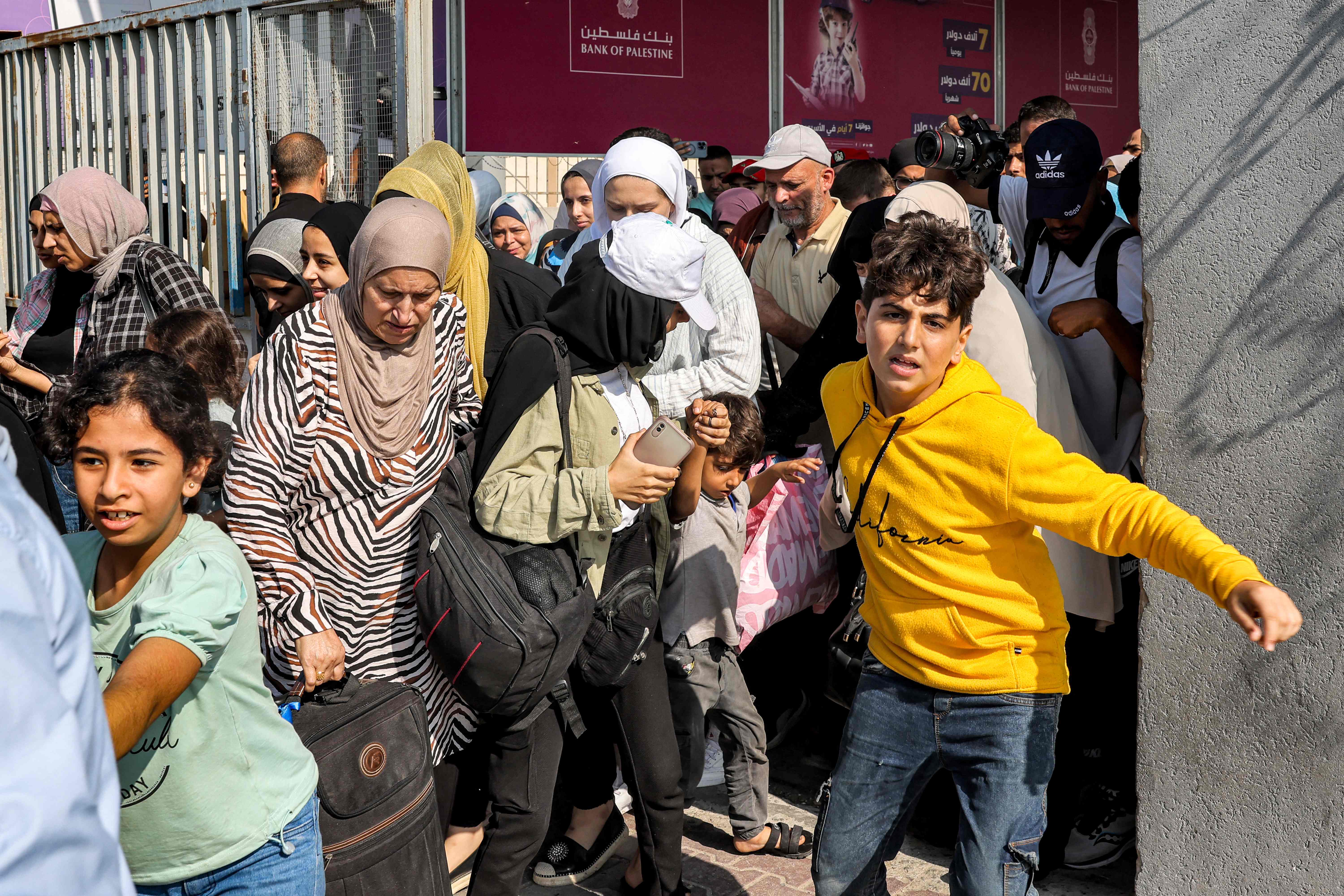 <p>People walk through a gate to enter the Rafah border crossing to Egypt </p>