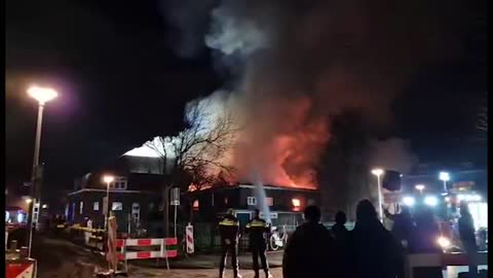 A large blaze consumes a church in Rotterdam as the roof caves in.