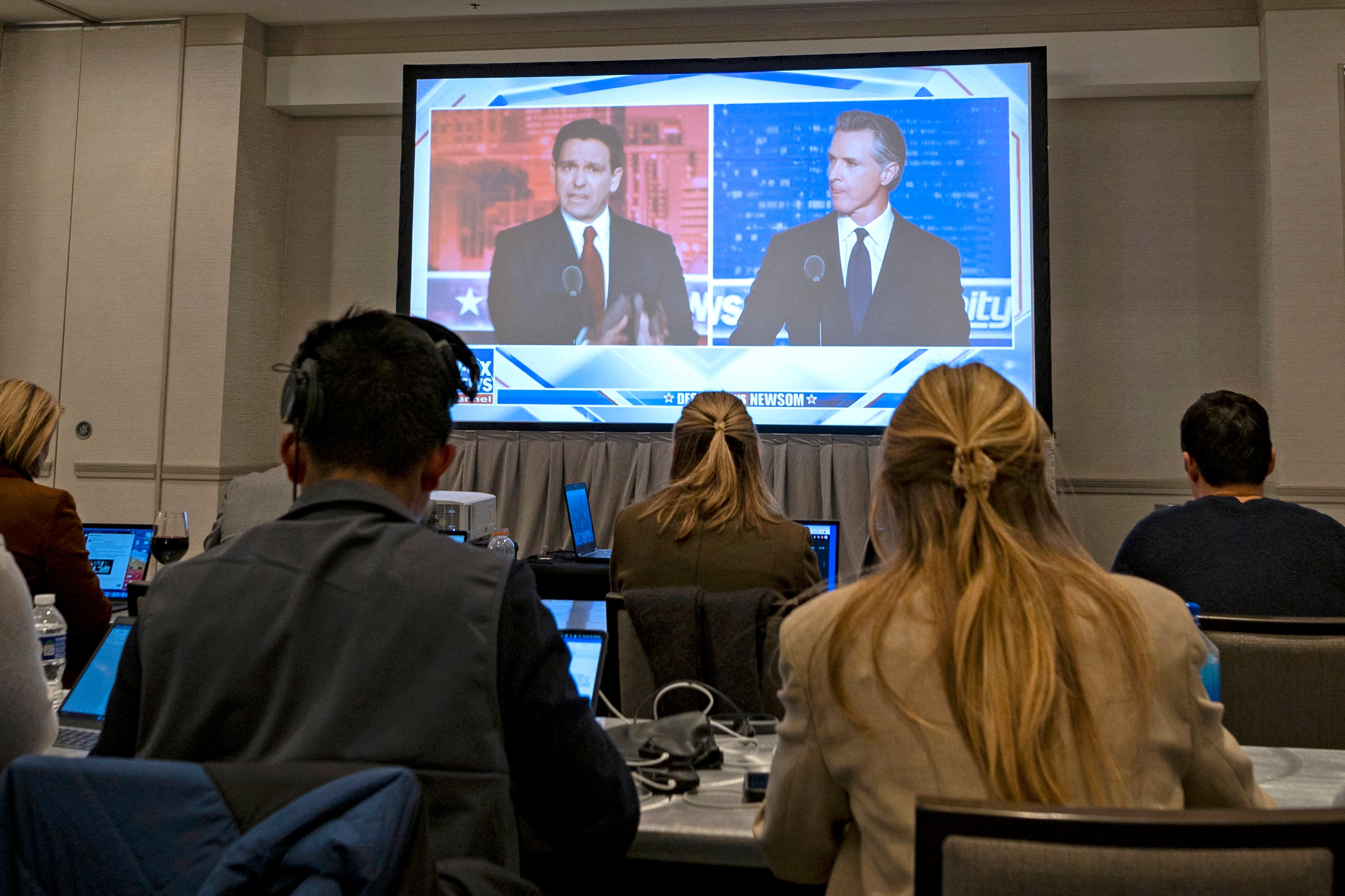 <p>Florida Governor and Republican presidential hopeful Ron DeSantis (L) and California Governor Gavin Newsom (R) appear on screen from the press room during a debate held by Fox News, in Alpharetta, Georgia, on November 30, 2023</p>