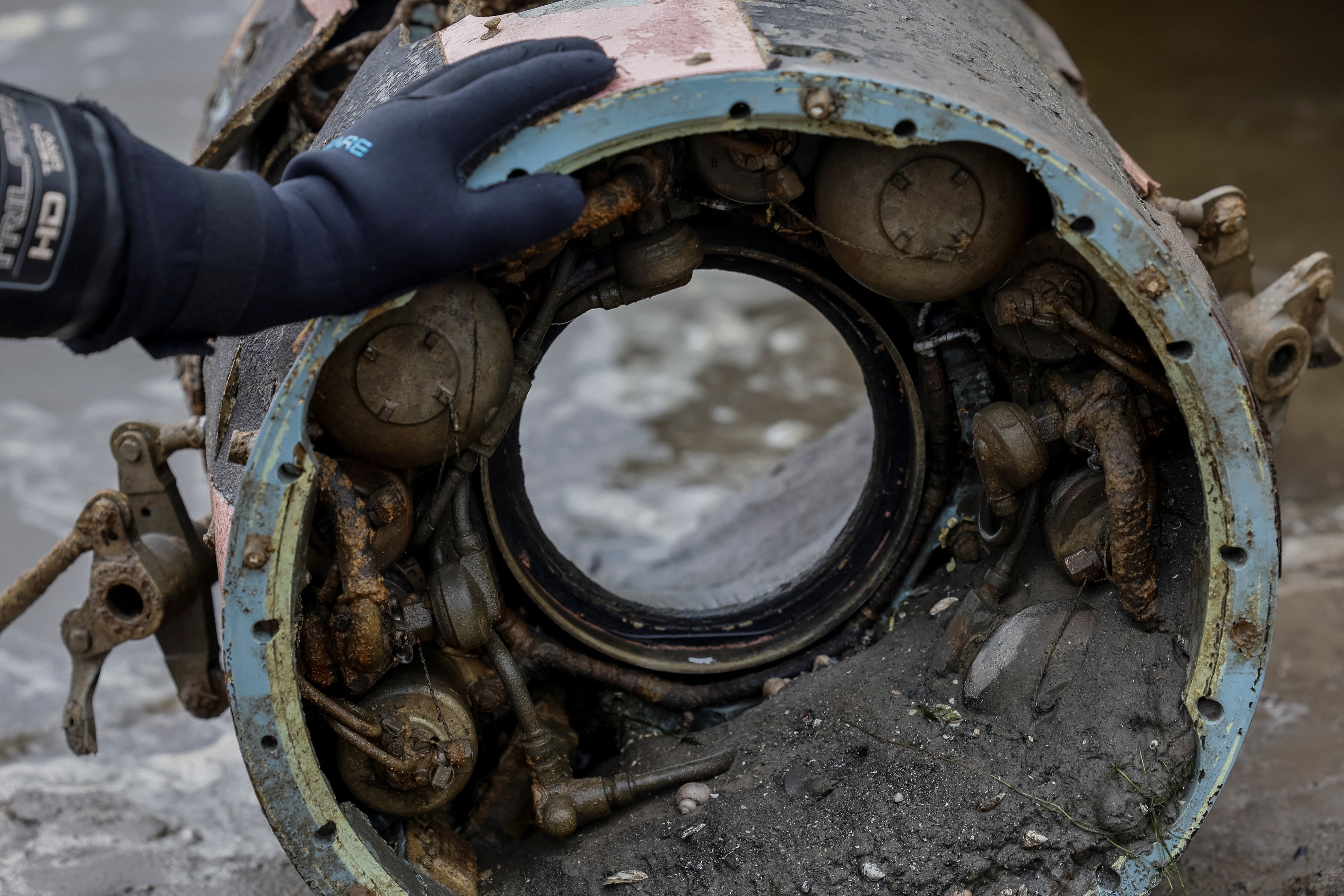 <p>A deminer touches the wreckage of a retrieved S-300 rocket, which fell a few months ago in the Dnipro river</p>
