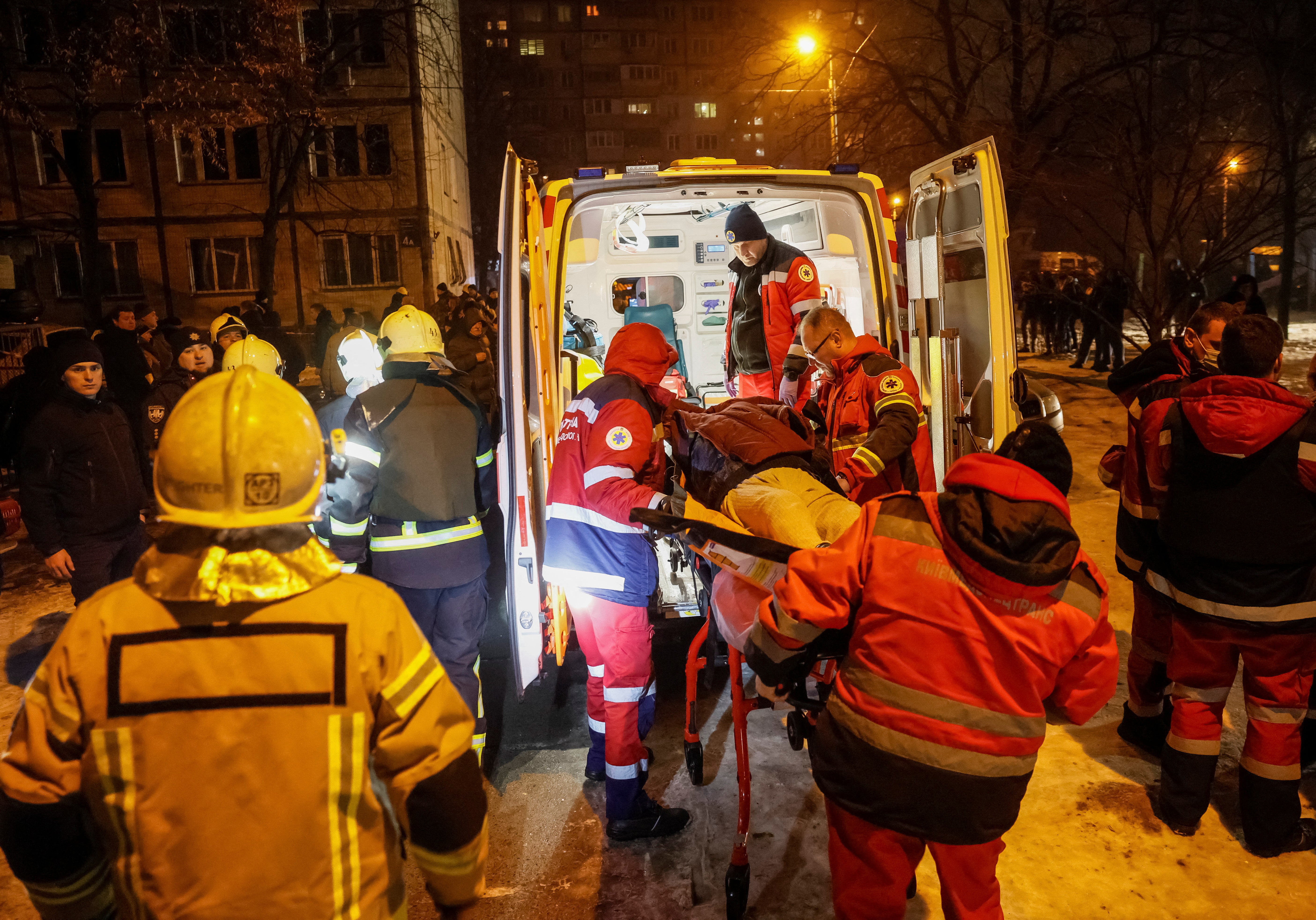 <p>Medics carry a wounded local resident at a site of an apartment building damaged during a Russian missile strike</p>