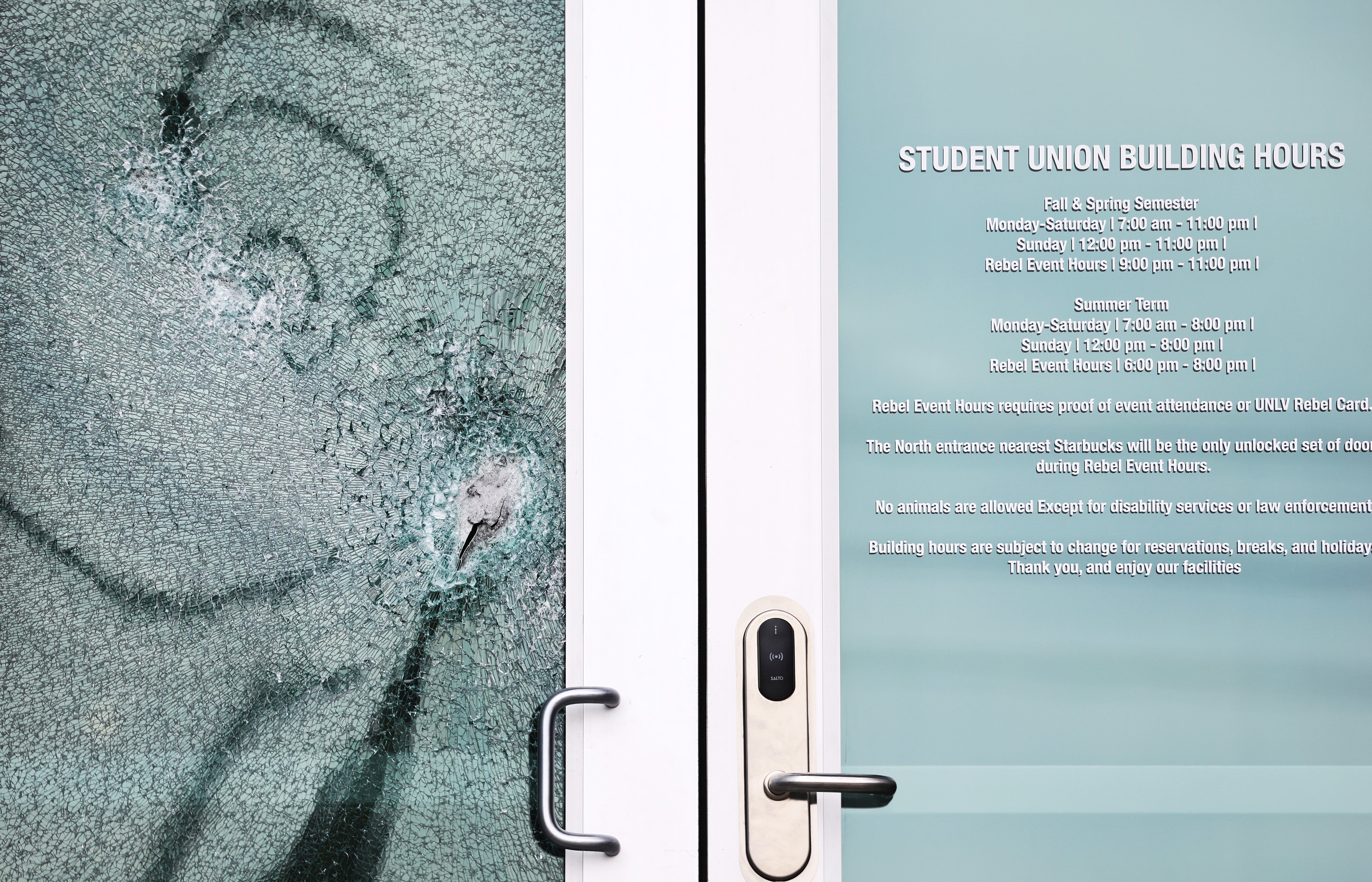 <p>A shattered door is viewed at the student union building the morning after a shooting left three dead at the University of Nevada</p>