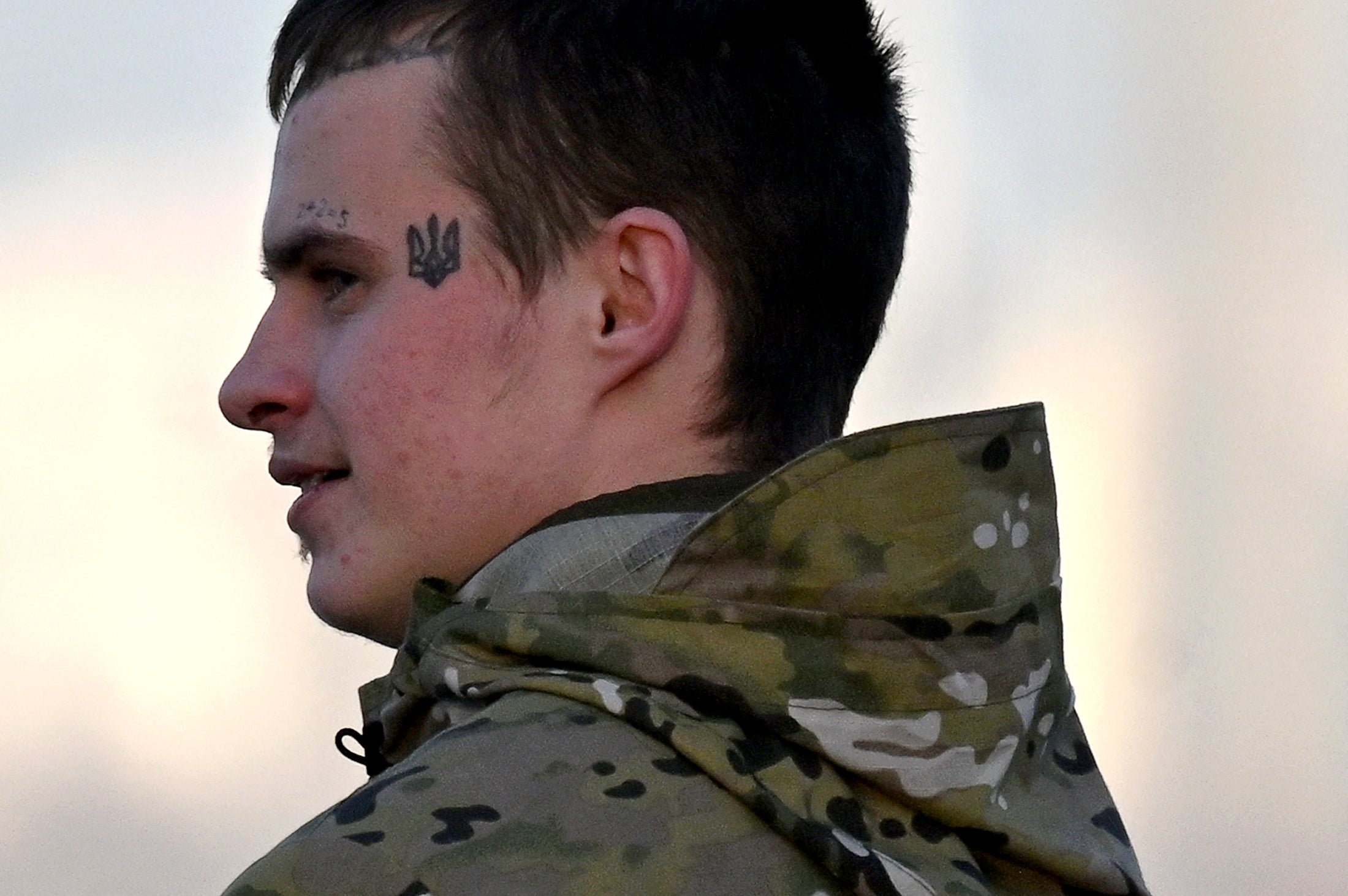 <p>A young Ukrainian serviceman, wearing a tattoo depicting the Ukrainian state coat of arms, walks in the center of the capital Kyiv</p>