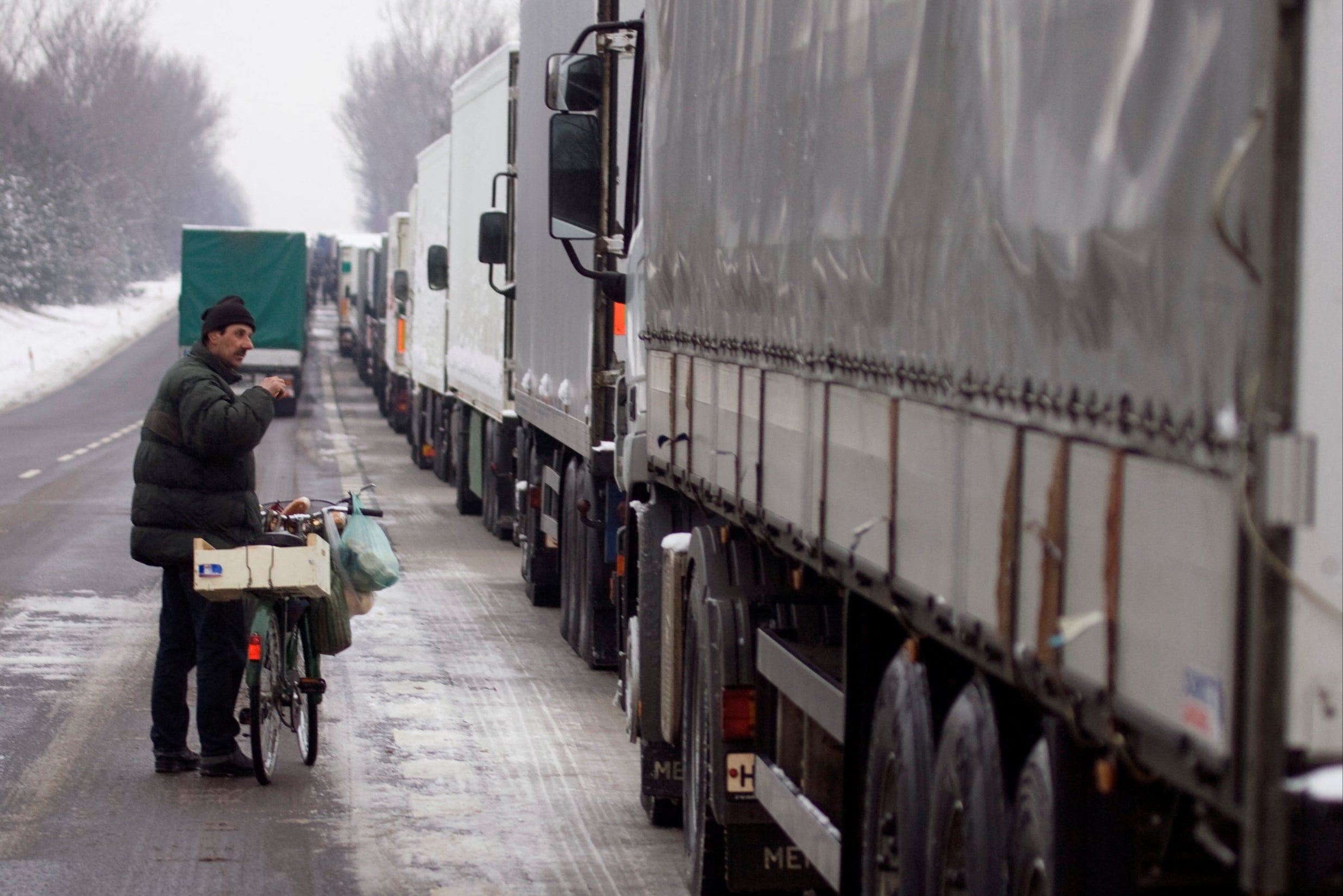 <p>A man offers food for sale to lorry drivers held up because of striking customs officers near Kukuryki at the Polish-Belarus border</p>