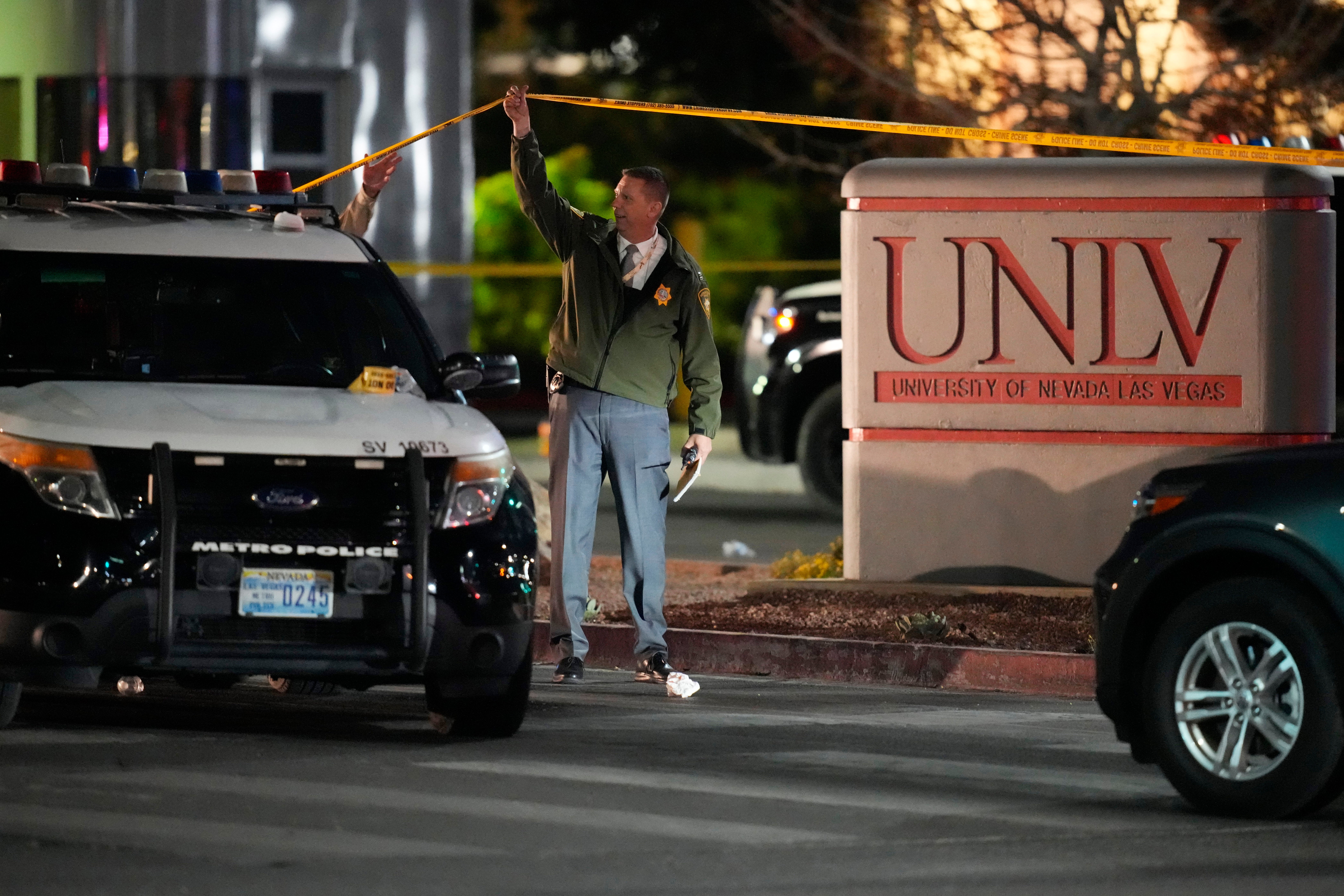 <p>A police officer walks under crime scene tape in the aftermath of a shooting at the University of Nevada</p>