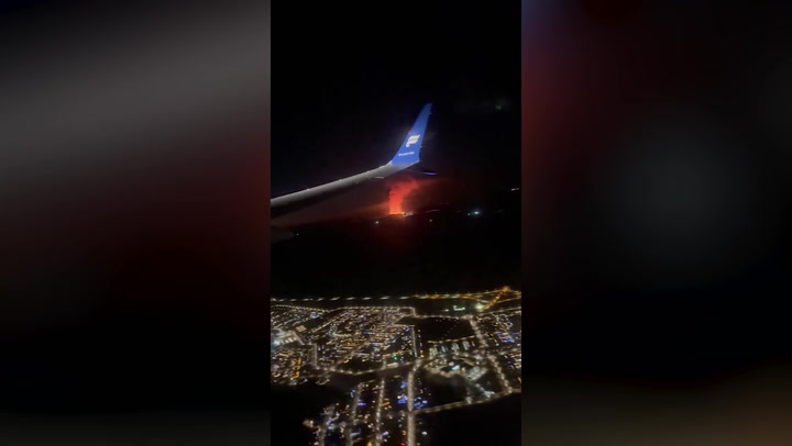 Passenger footage captured the view of Iceland's volcano eruption from a plane window.