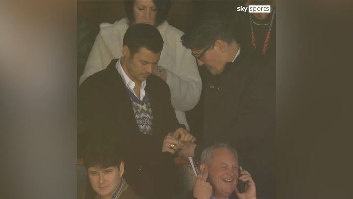 Harry Styles and Mick Harford are seen sharing mints while watching the Luton Town vs Manchester United game in the stands.