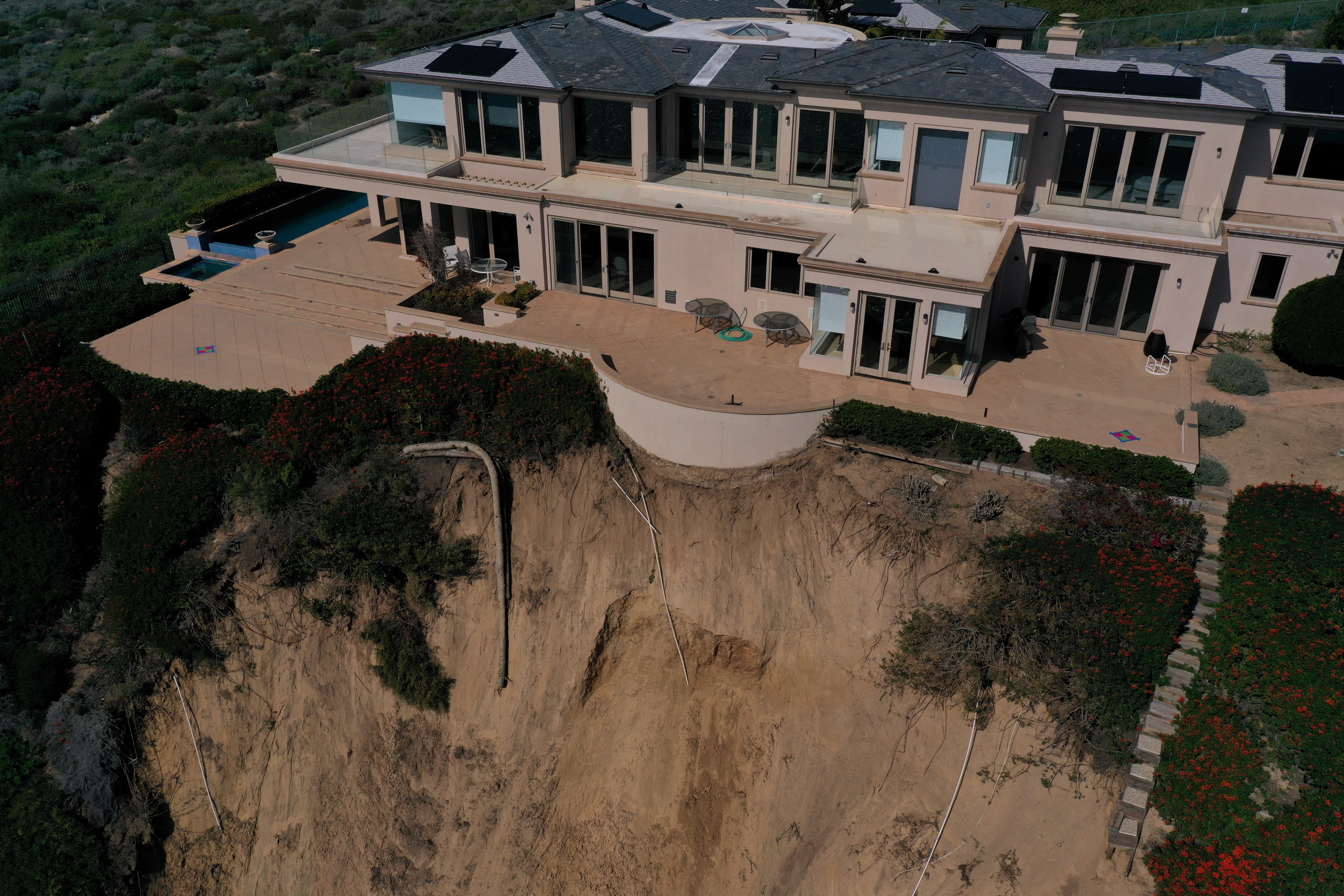 

<p>An aerial image shows homes along Scenic Drive standing on the edge of a cliff above the Pacific Ocean after a landslide following heavy rains in Dana Point, California, on February 15</p>
<p>” height=”3648″ width=”5472″ layout=”responsive” i-amphtml-layout=”responsive”><i-amphtml-sizer slot=