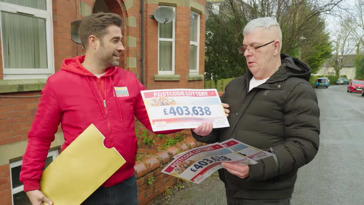 The largest winner of the Postcode Lottery is still in disbelief as he receives his check.