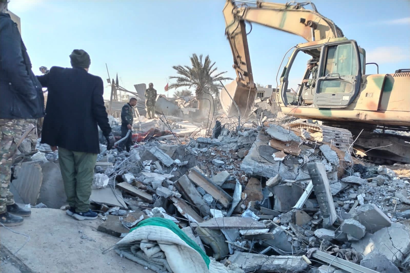 

<p>Members of Iraqi Shiite Popular Mobilization Forces clean the rubble after a US airstrike in al-Qaim, Iraq</p>
<p>” height=”1066″ width=”1599″ layout=”responsive” i-amphtml-layout=”responsive”><i-amphtml-sizer slot=