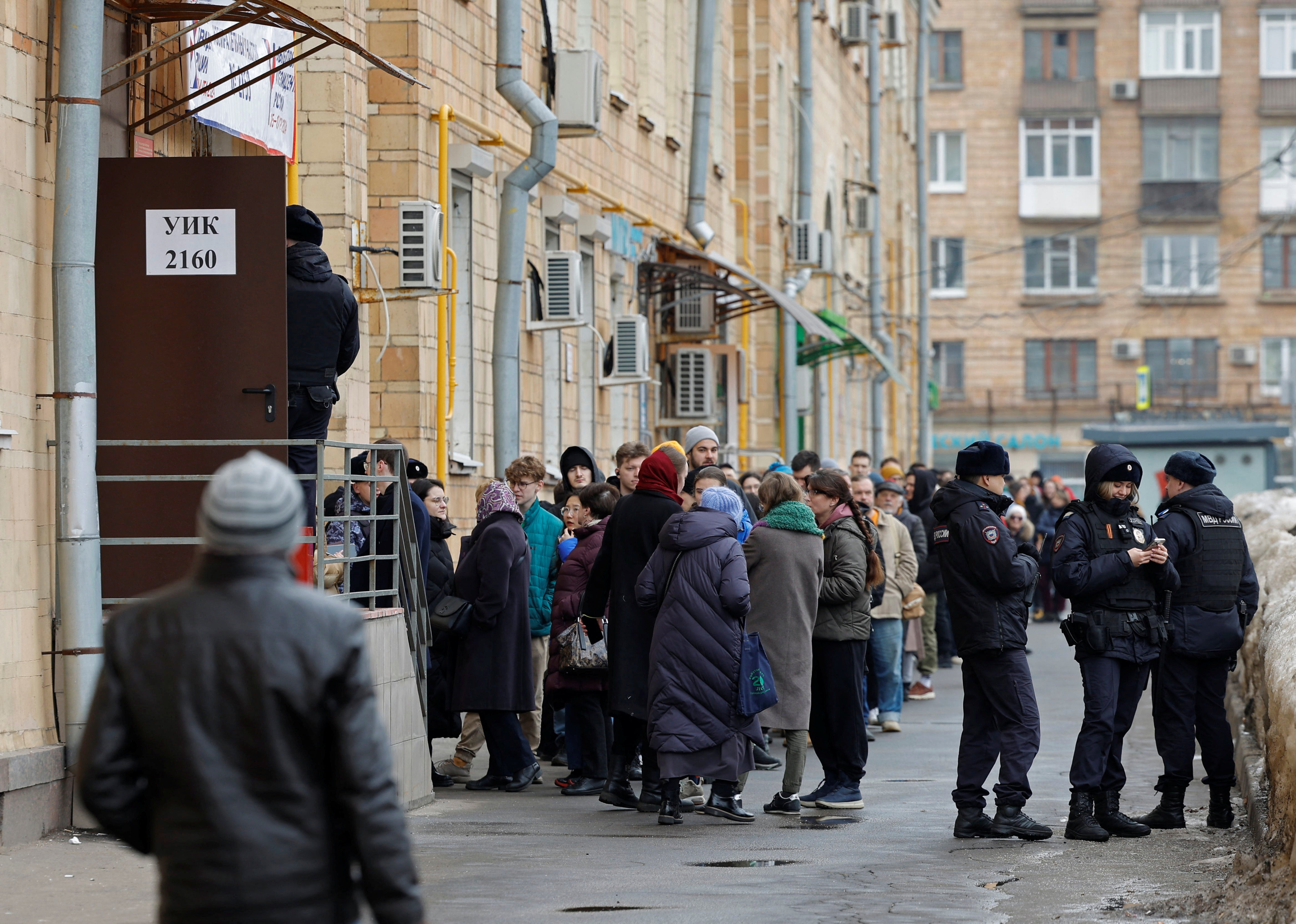 

<p>Police officers stand guard next to Russians queuing at a polling station in Moscow around noon on Sunday</p>
<p>” height=”3335″ width=”4678″ layout=”responsive” i-amphtml-layout=”responsive”><i-amphtml-sizer slot=