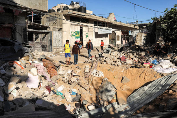 Children stand by an impact crater at the site of a building that was hit by Israeli bombardment in Rafah in the southern Gaza Strip on 8 May 2024
