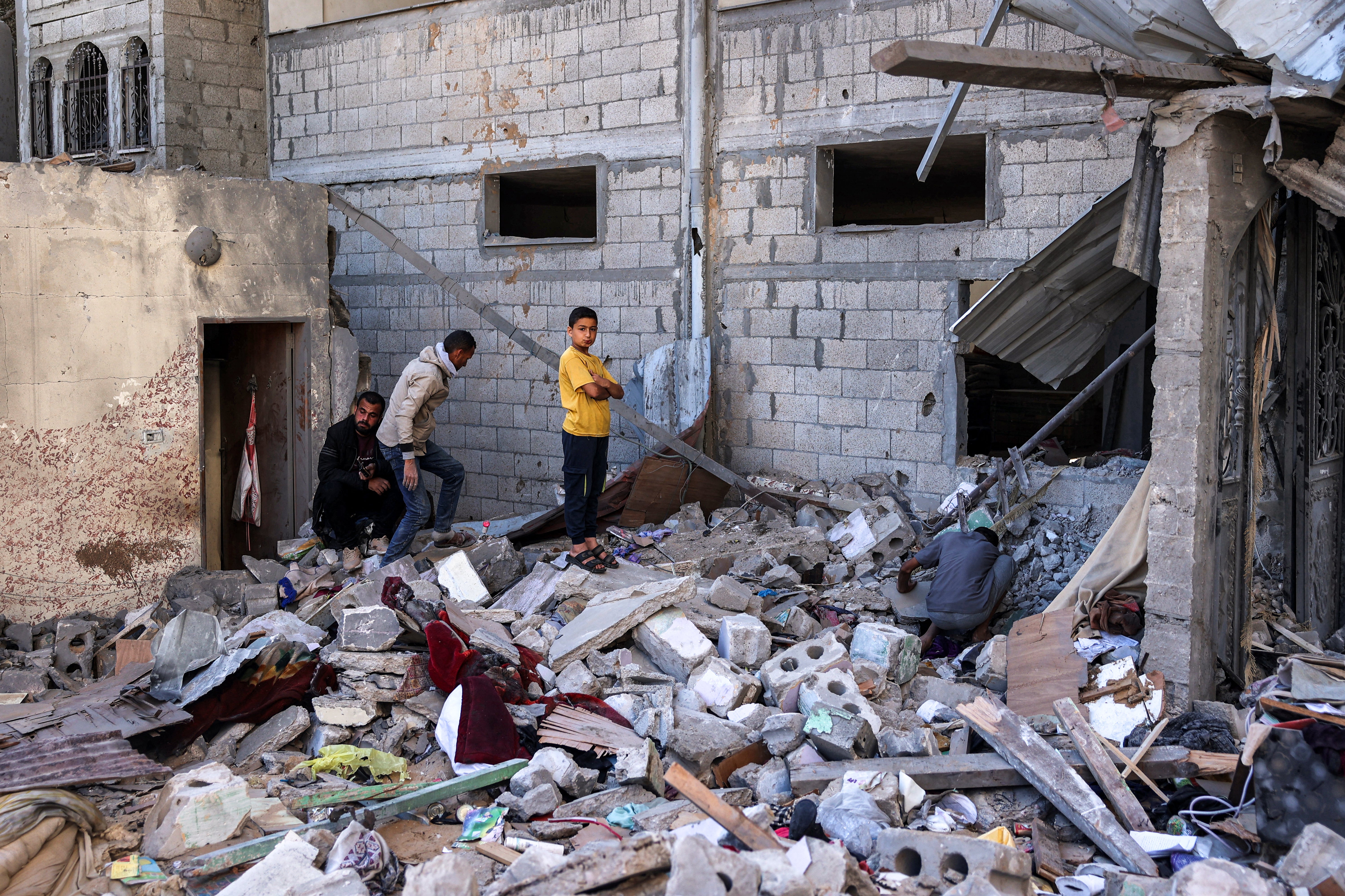 Men and a boy inspect the site of a building that was hit by Israeli bombardment in Rafah in the southern Gaza Strip on 8 May 2024 amid the ongoing conflict in the Palestinian territory between Israel and the militant group Hamas