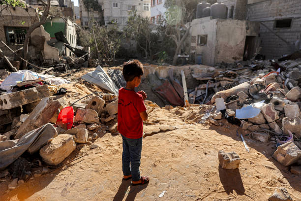 A boy stands before an impact crater at the site of a building that was hit by Israeli bombardment in Rafah in the southern Gaza Strip on 8 May 2024