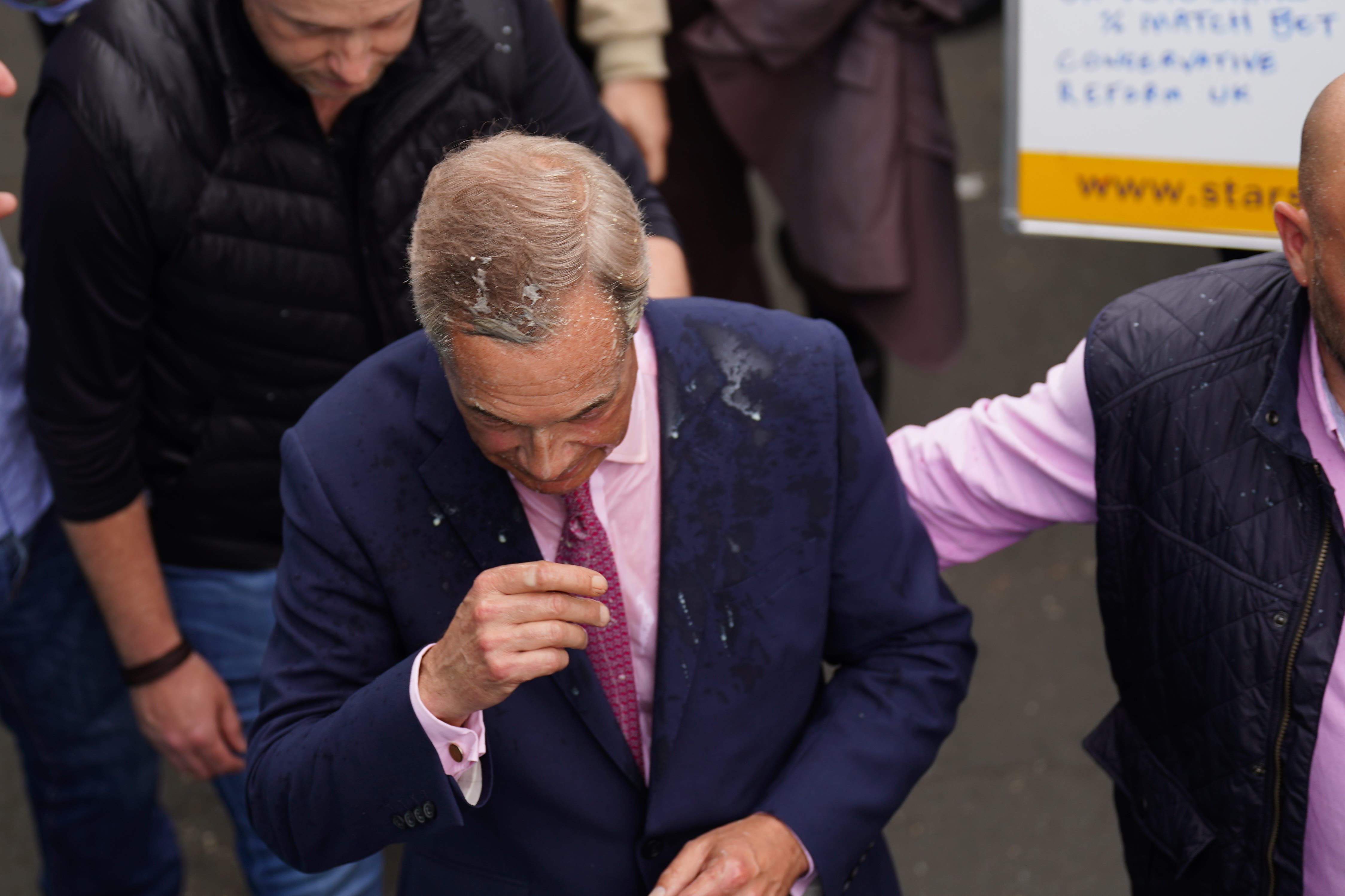 Leader of Reform UK Nigel Farage after a drink was thrown over him as he leaves the Moon and Starfish pub in Clacton