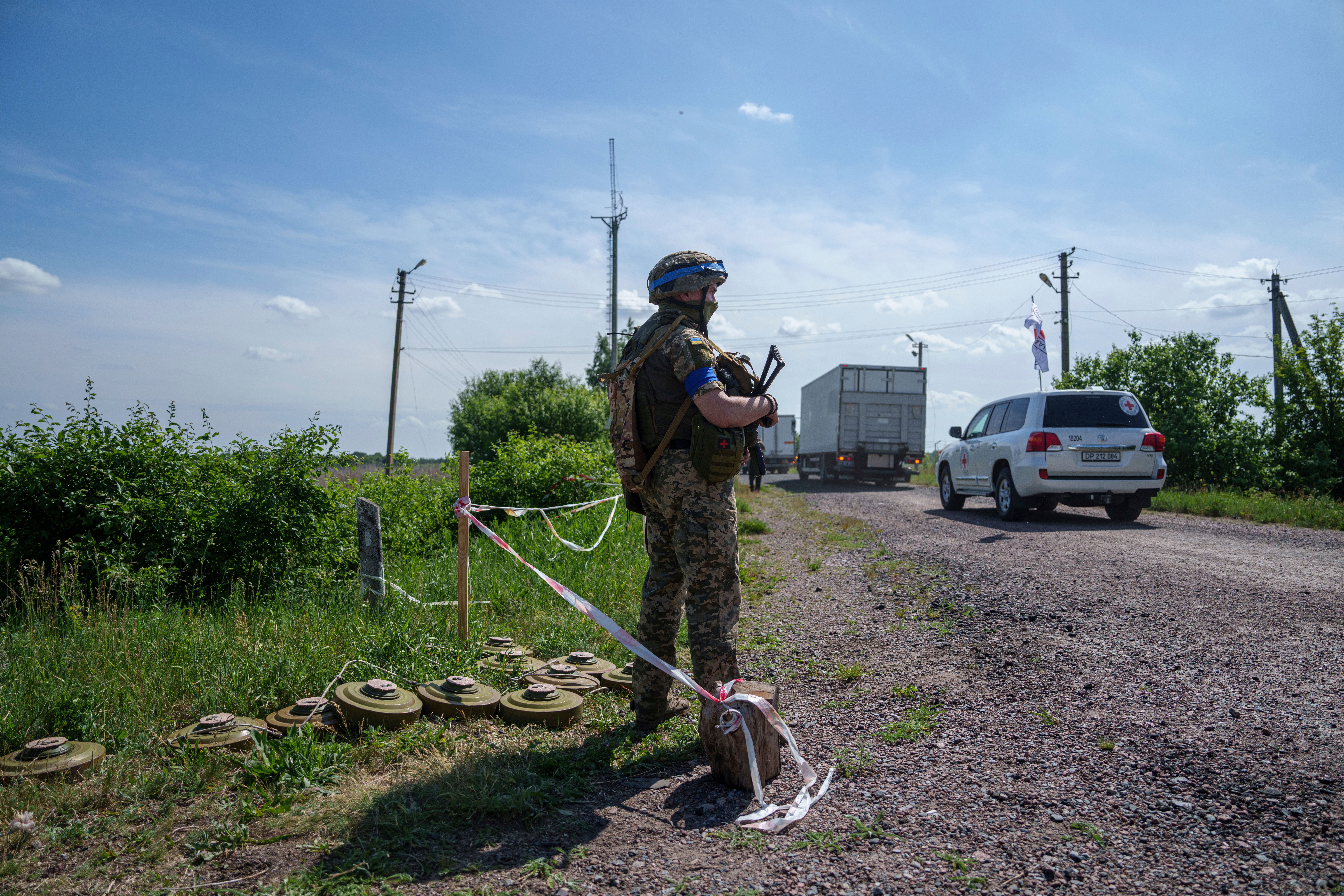 An Ukrainian soldier guards his position while trucks with killed Russian soldiers driving to Russian territory, during repatriation in Sumy region, Ukraine, Friday, 31 May 2024