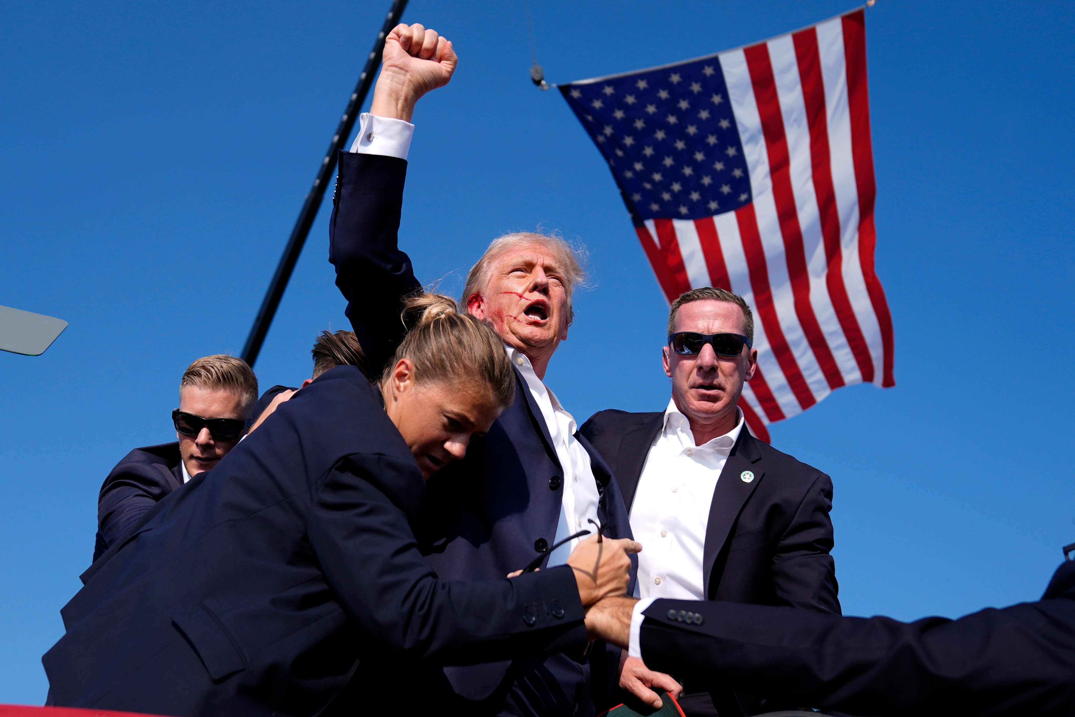 Donald Trump raises a fist in defiance after being shot at in Butler, Pennsylvania, on Satrurday