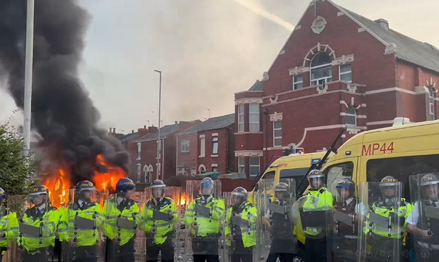 A police van set alight as trouble flares during a protest in Southport