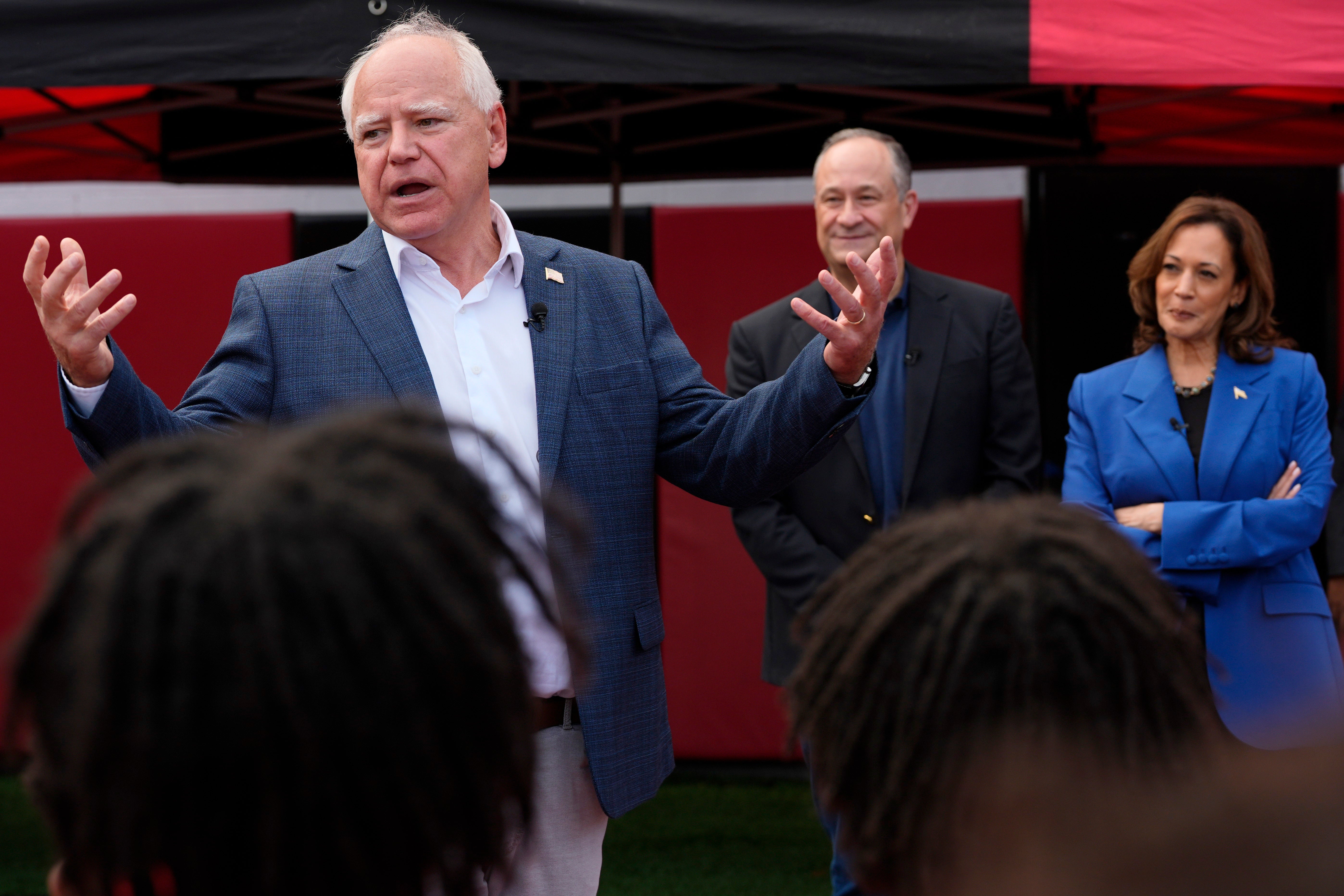 Democratic vice presidential nominee Tim Walz speaks with members of the Aliquippa High School football team during a campaign bus tour stop