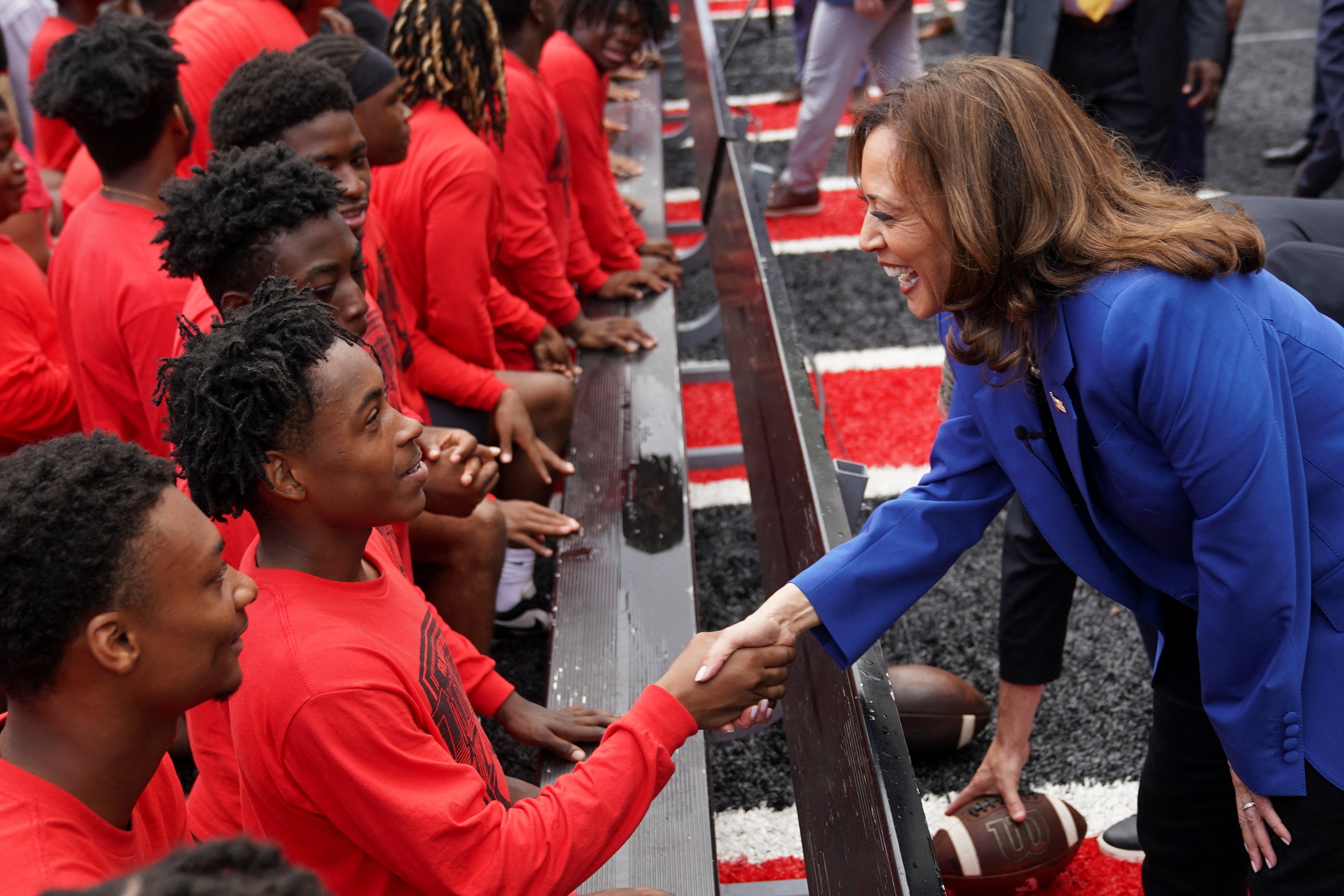 Democratic presidential candidate and U.S. Vice President Kamala Harris meets members of the high school football team