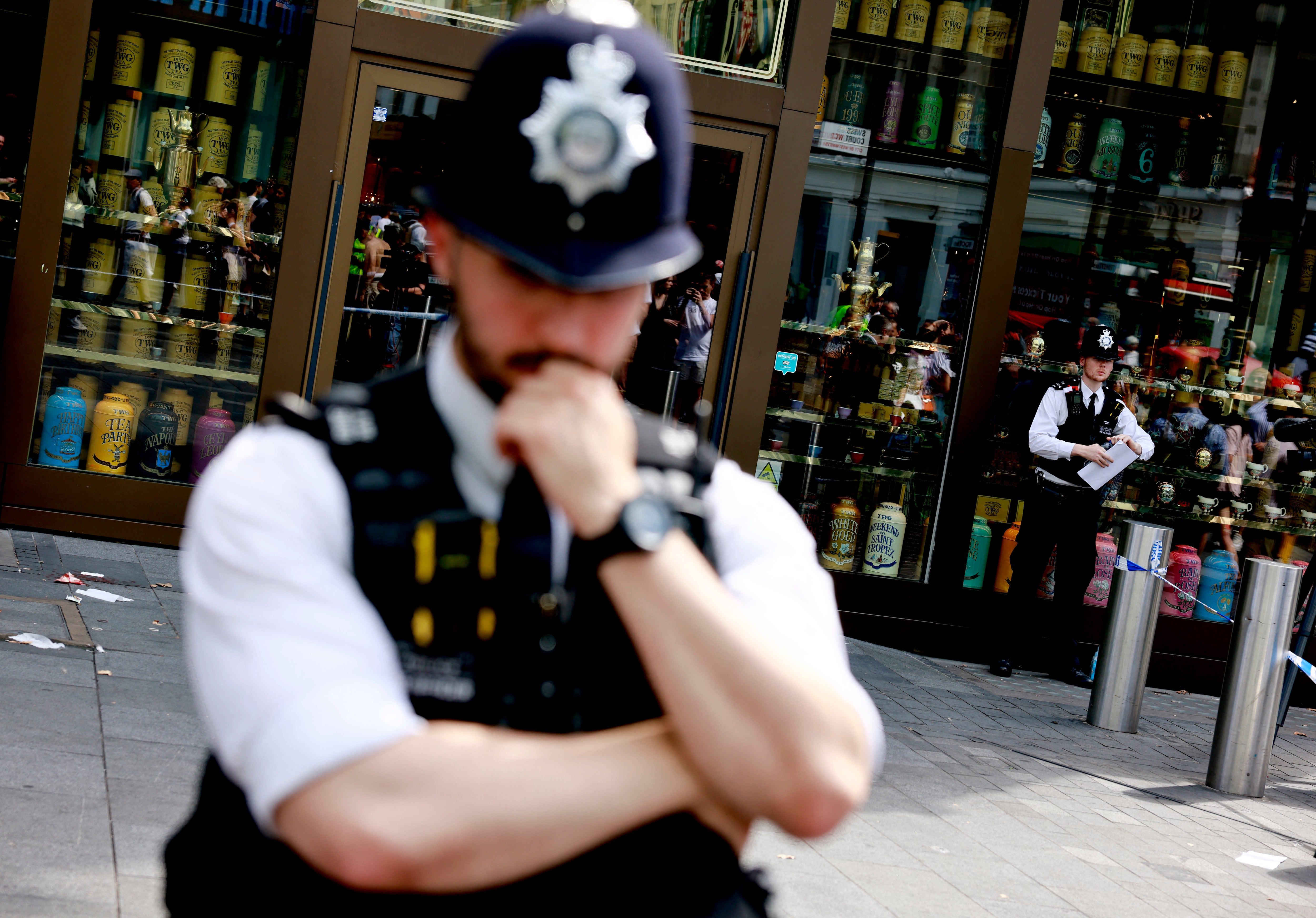 A photograph taken on August 12, 2024 shows police officers standing by a cordoned off area in Leicester square, London