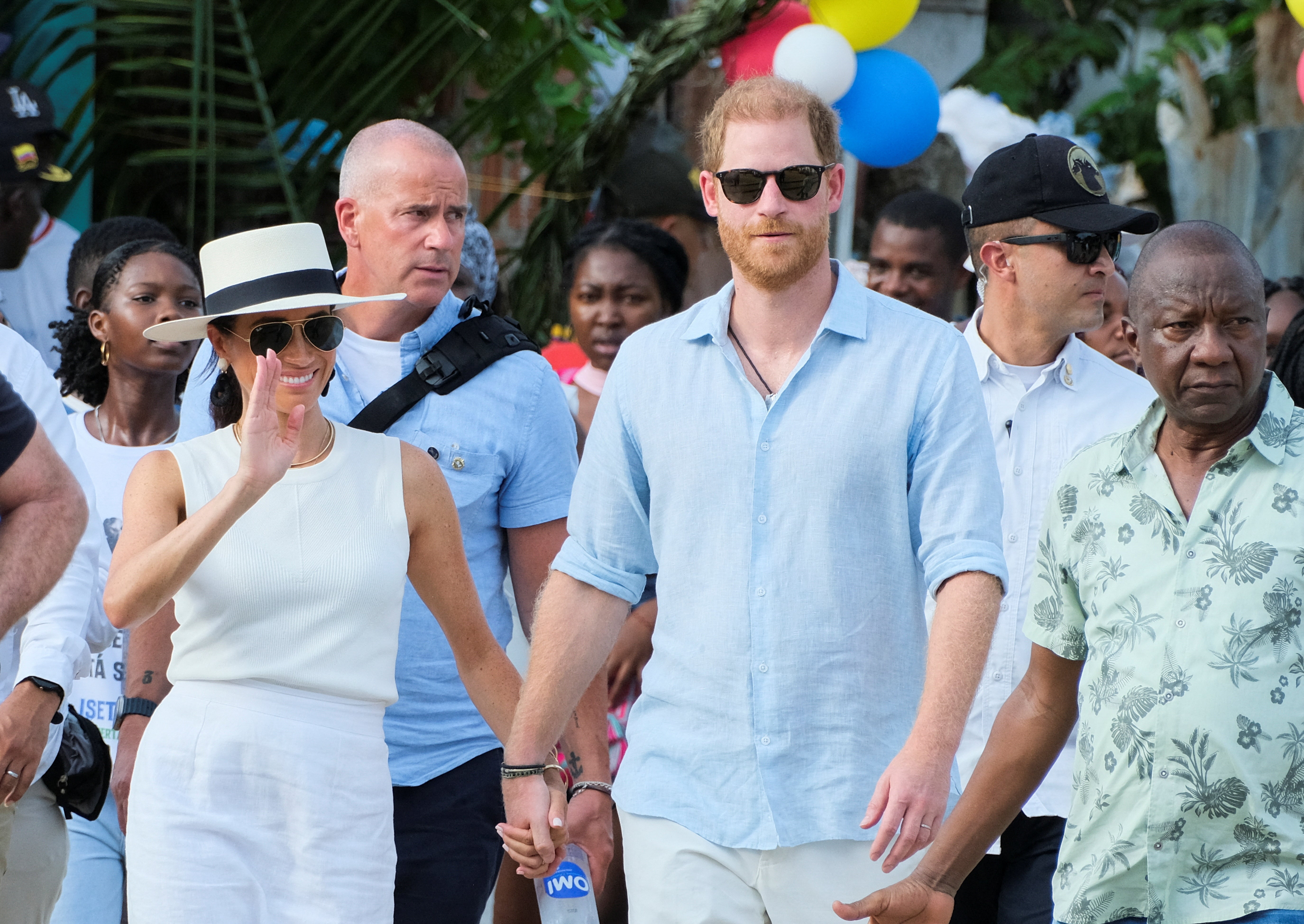 Britain's Prince Harry and his wife Meghan, Duchess of Sussex, walk together in San Basilio de Palenque, Colombia