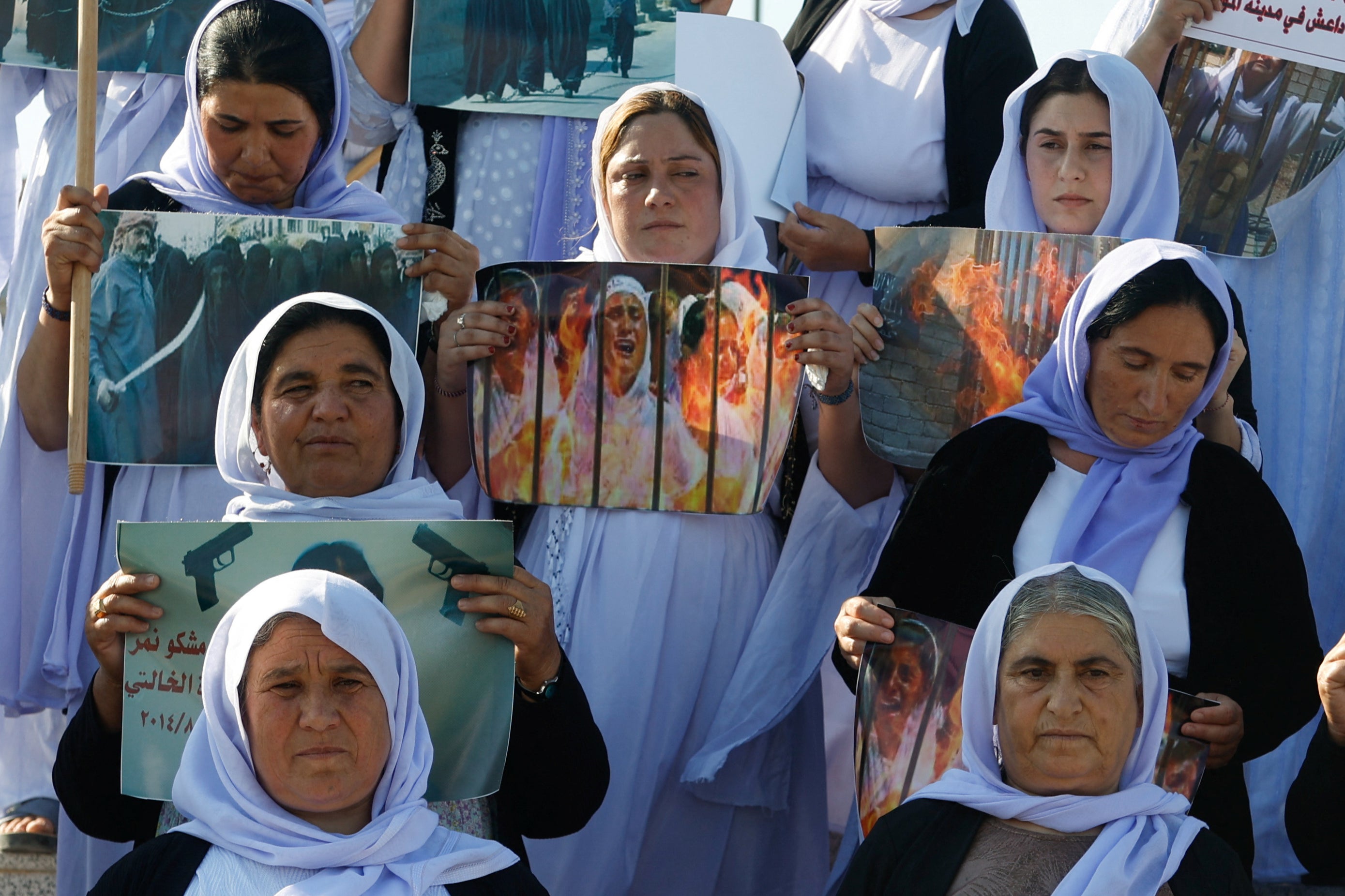 Yazidi women raise banners during a demonstration demanding their rights and the release of those kidnapped by Isis, in Mosul, Iraq