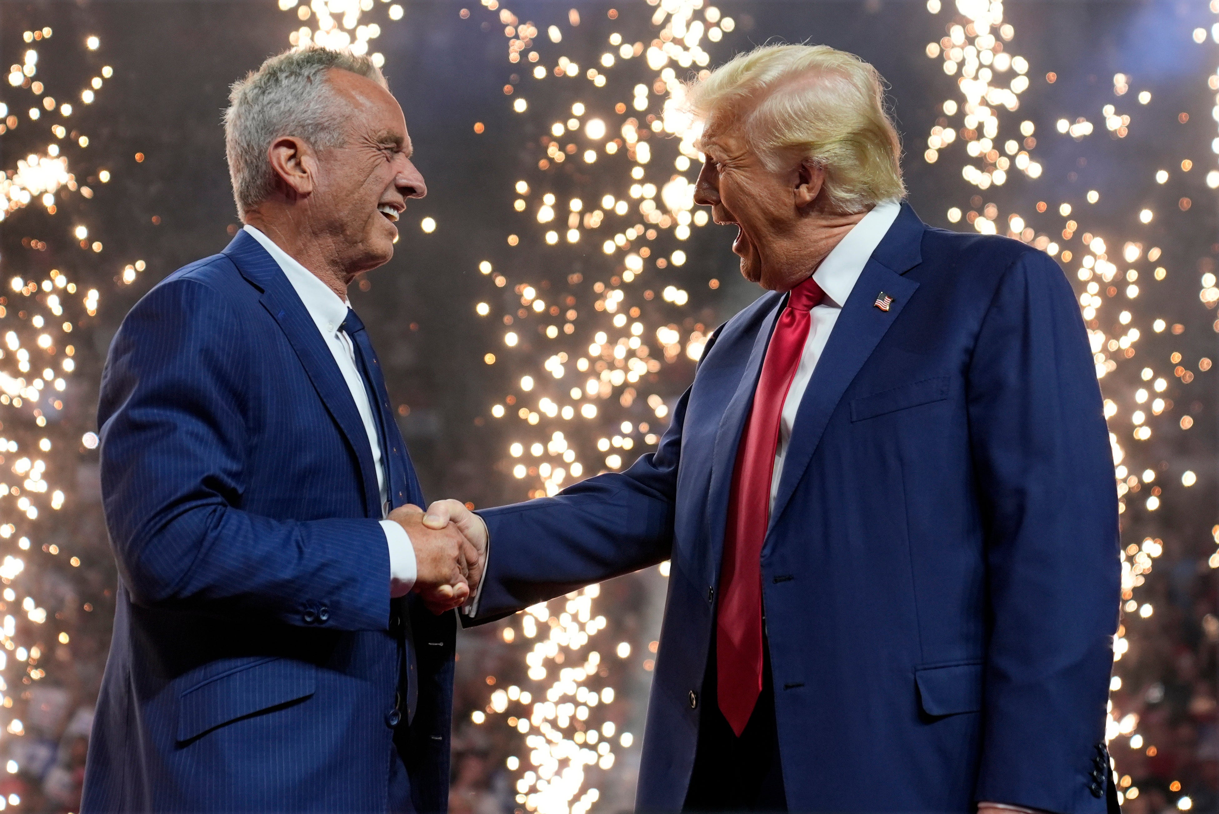 Republican presidential nominee former President Donald Trump shakes hands with Independent presidential candidate Robert F. Kennedy Jr. at a campaign rally at the Desert Diamond Arena, Friday, Aug. 23, 2024, in Glendale, Ariz. (AP Photo/Evan Vucci)