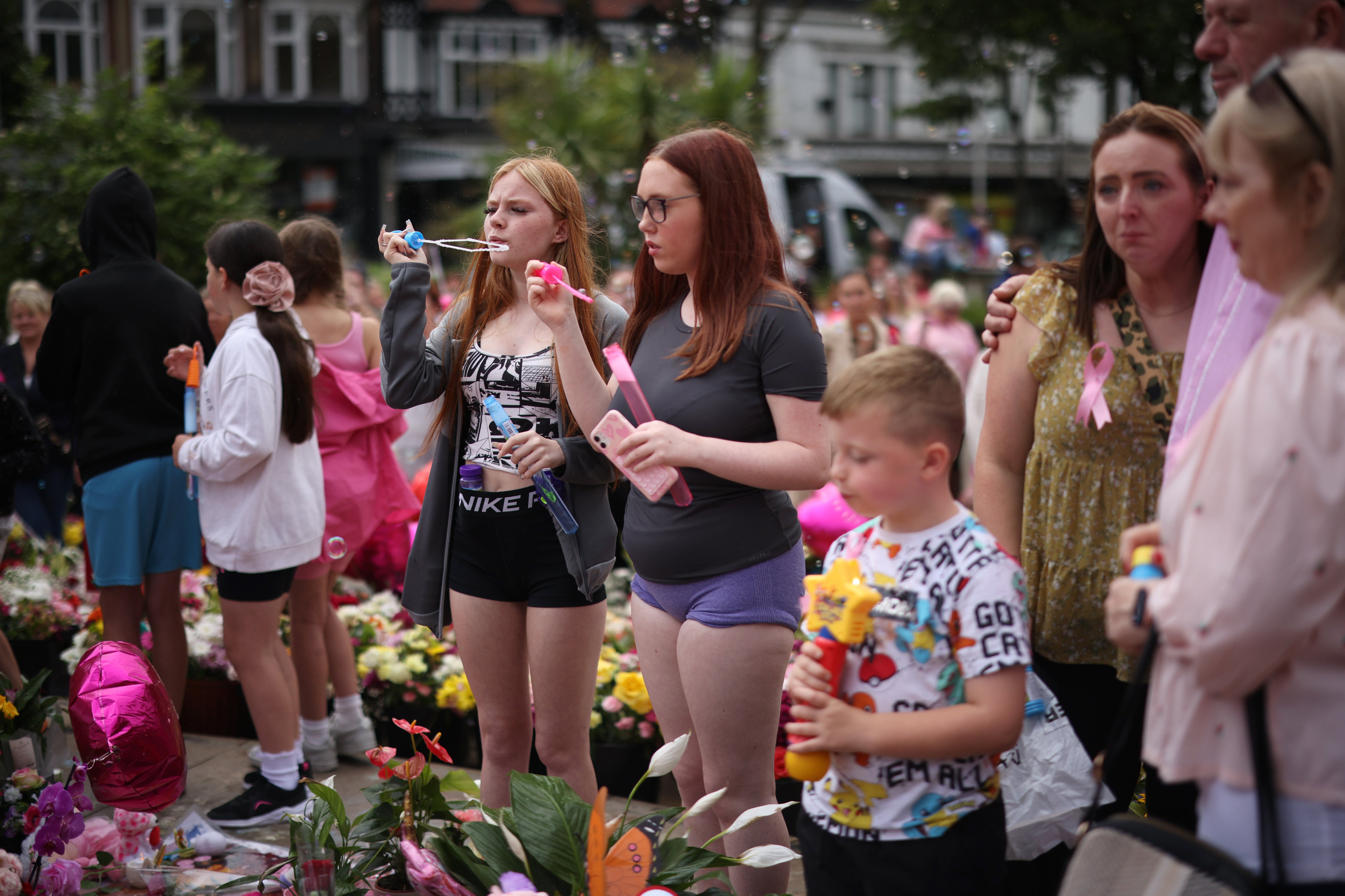 Two children blow bubbles at a vigil for the three victims of a knife attack in Southport last week