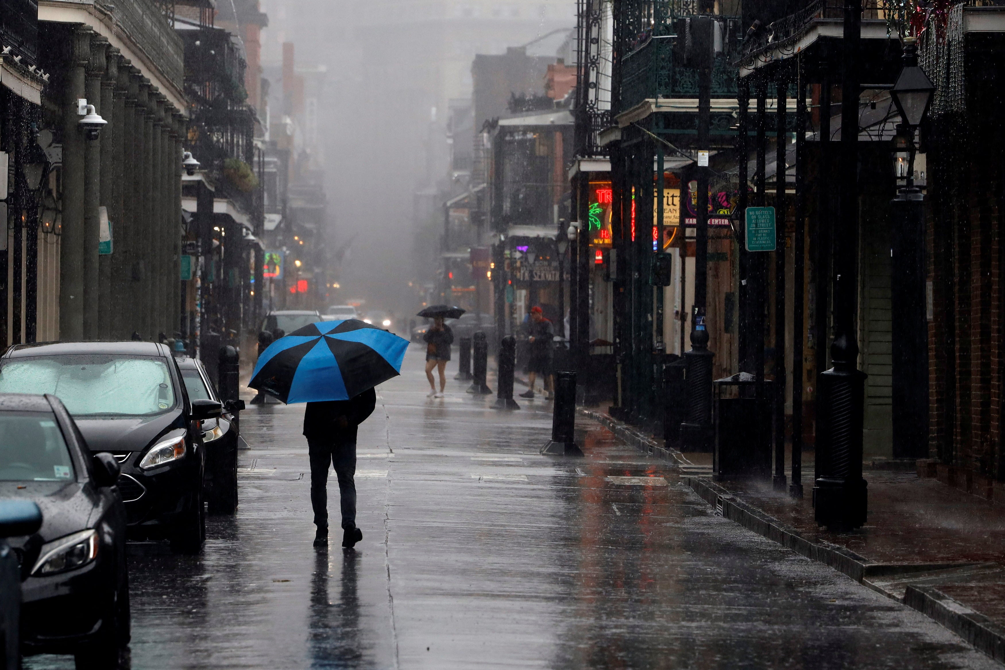 A person in a raincoat walks by the waves from Lake Pontchartrain as they crash against the seawall in New Orleans on Wednesday. Hurricane Francine made landfall late Wednesday afternoon.