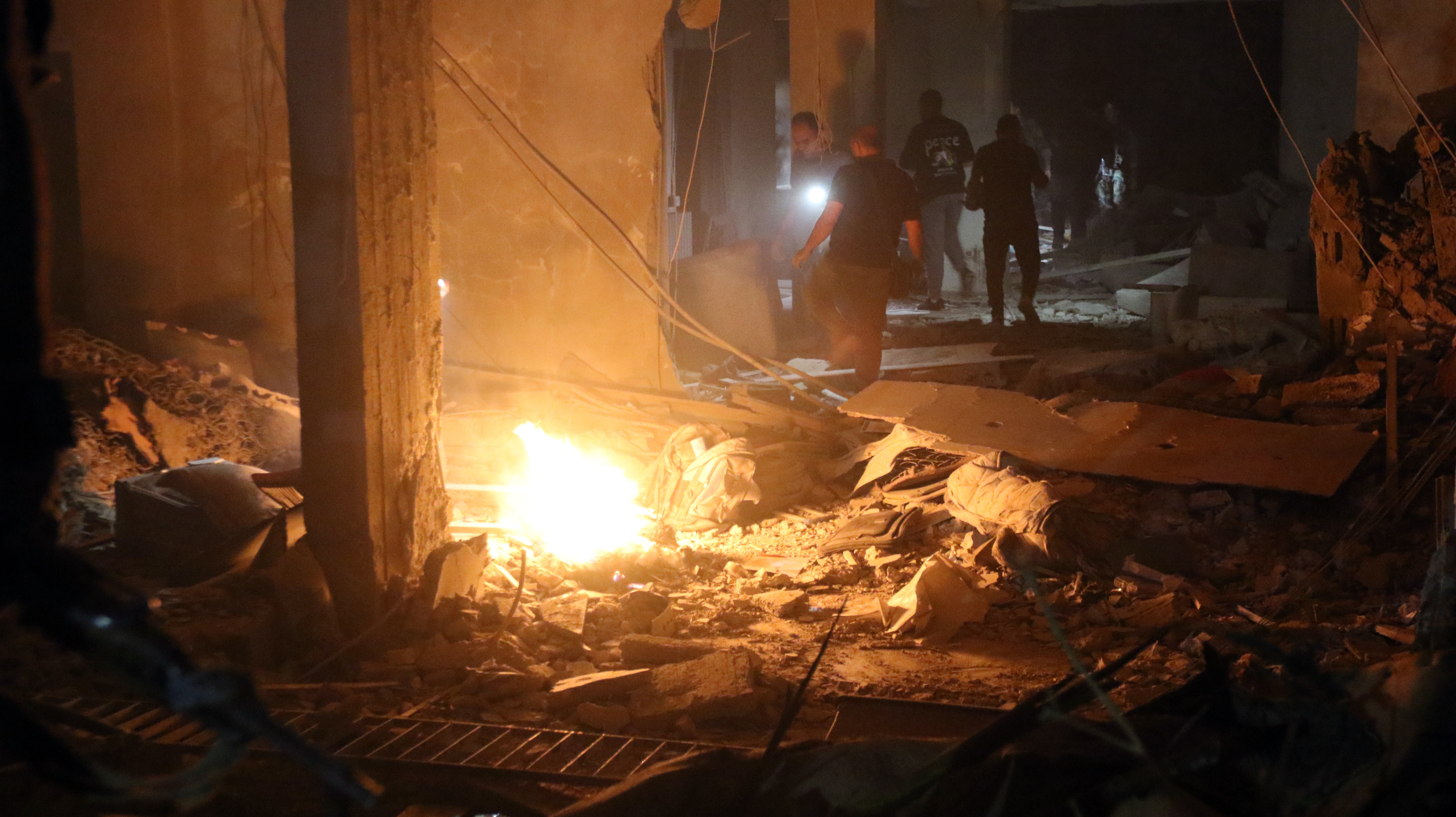 People inspect the site of a military strike in the Al-Mazzeh neighborhood in Damascus, Syria, on Wednesday