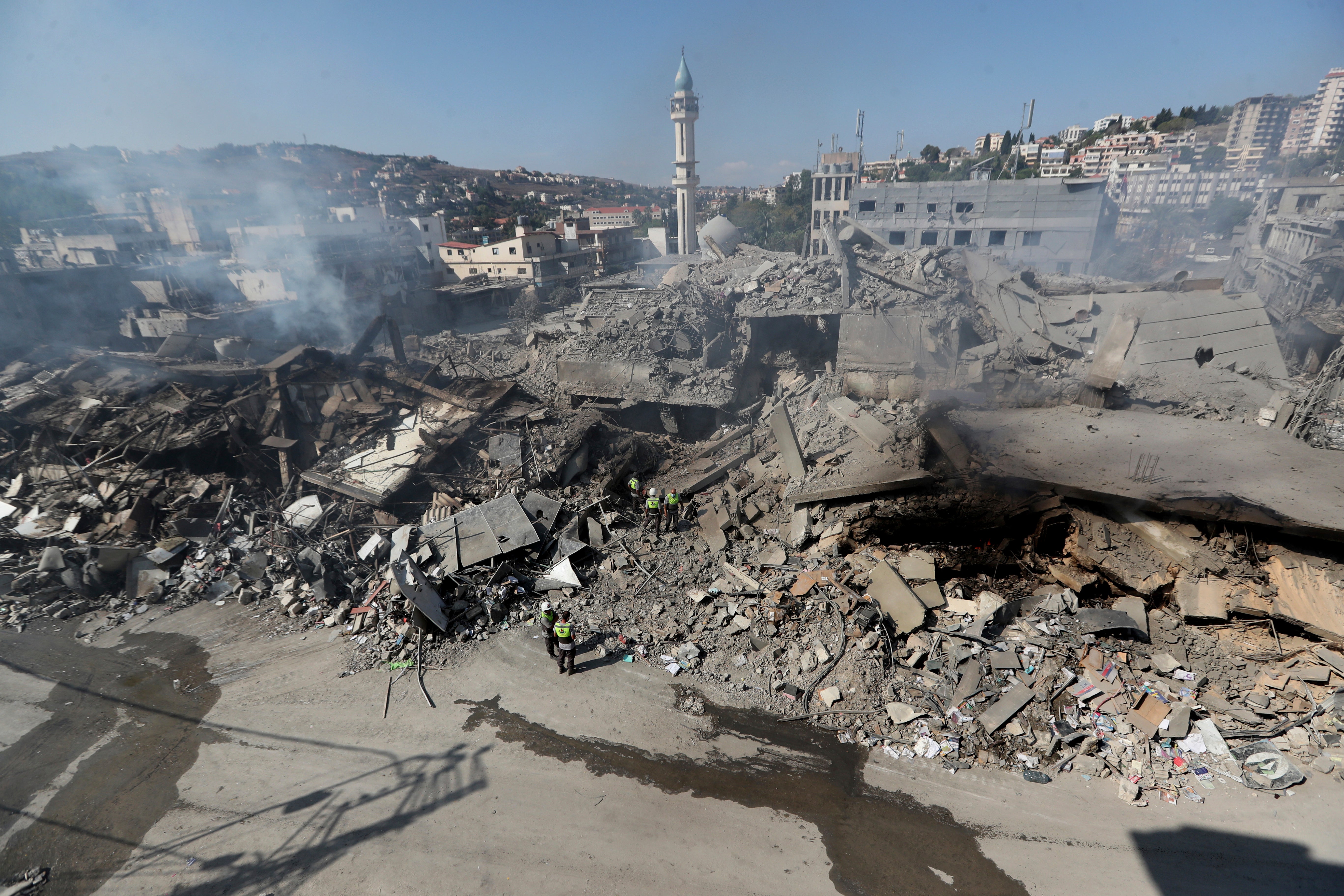 Hezbollah rescue workers search for victims amid the rubble of destroyed buildings