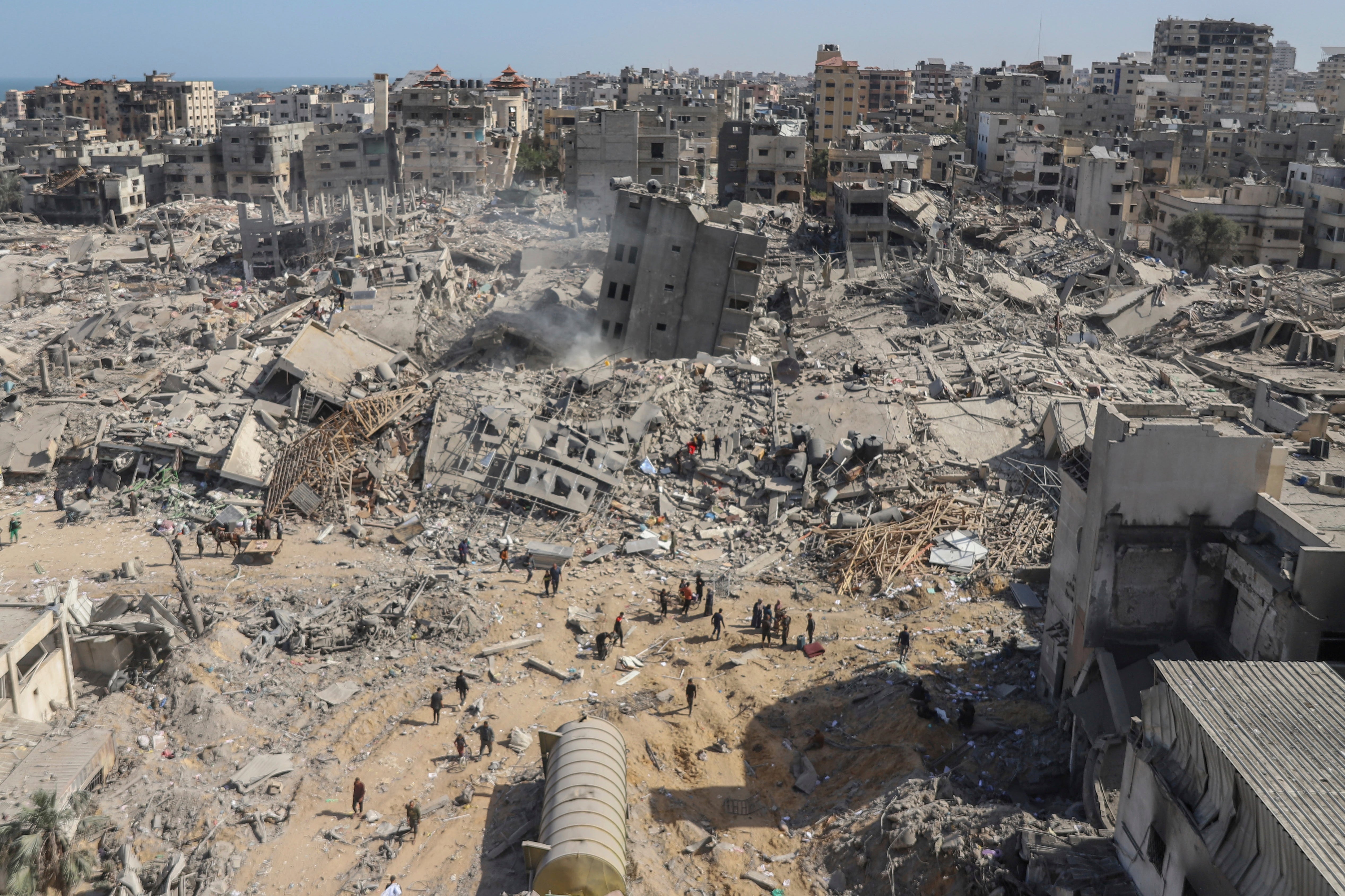 Palestinians walk through the destruction left by the Israeli air and ground offensive on the Gaza Strip