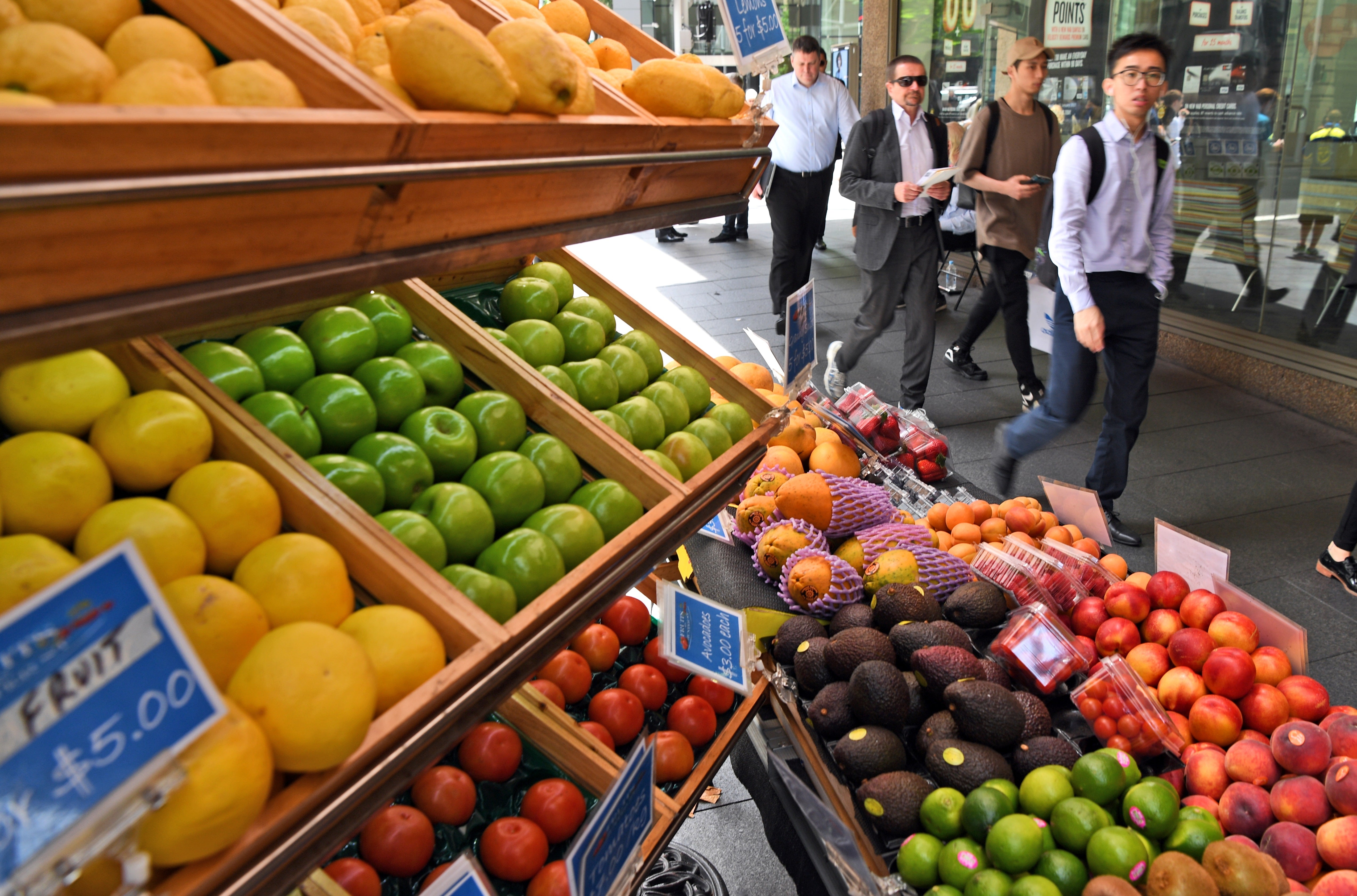 People walk past a fruit stall in Sydney’s central business district