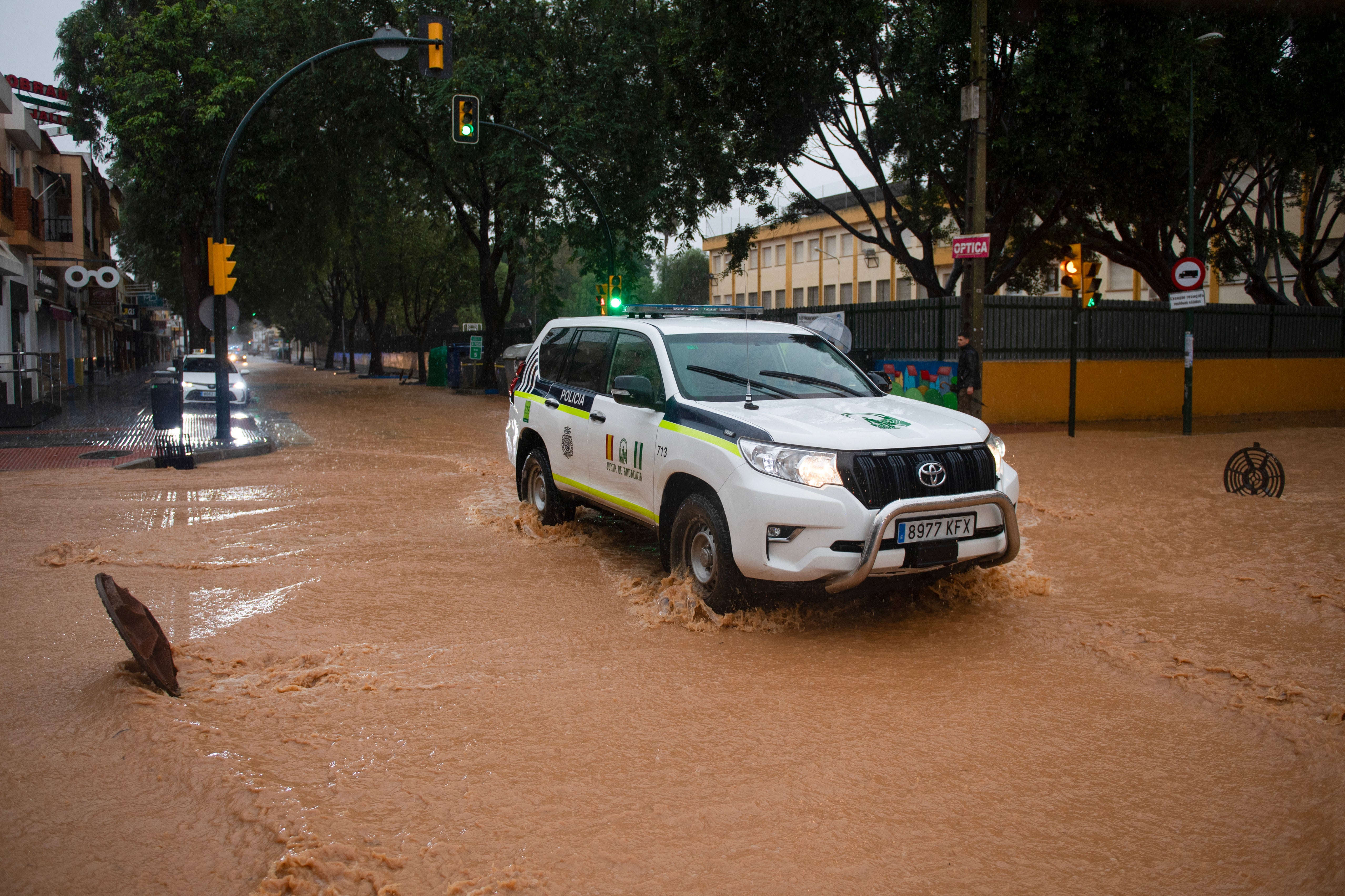 A police car potrols down a flooded street in Campanillas on Wednesday