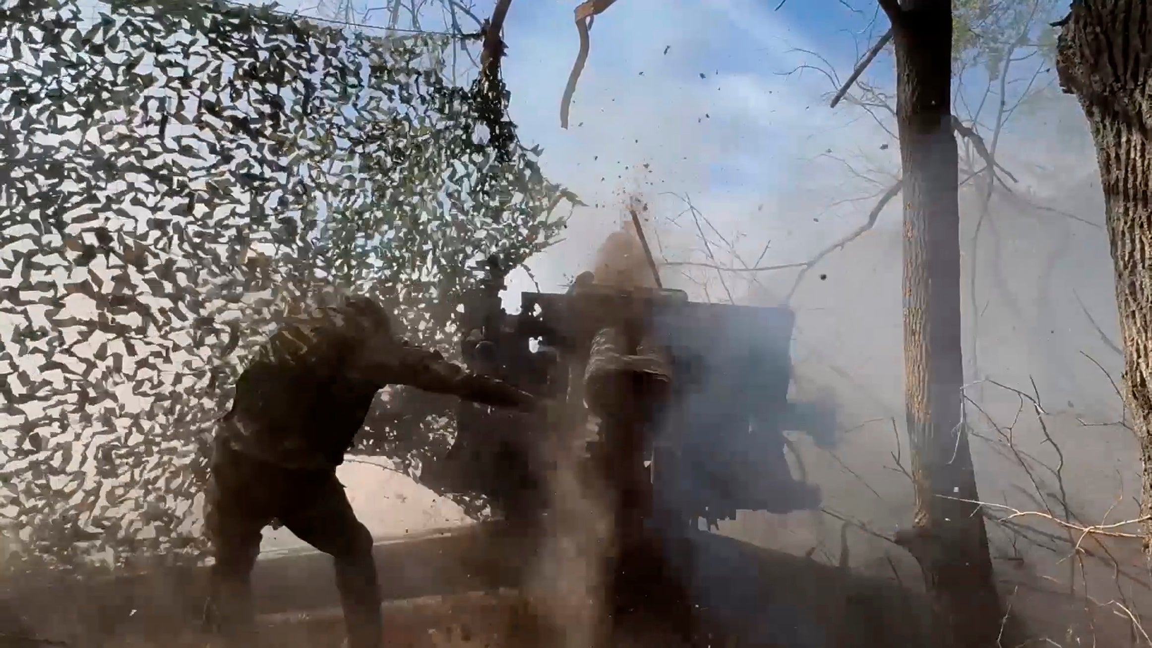 A Russian soldier fires from a howitzer toward Ukrainian position in the Russian - Ukrainian border area