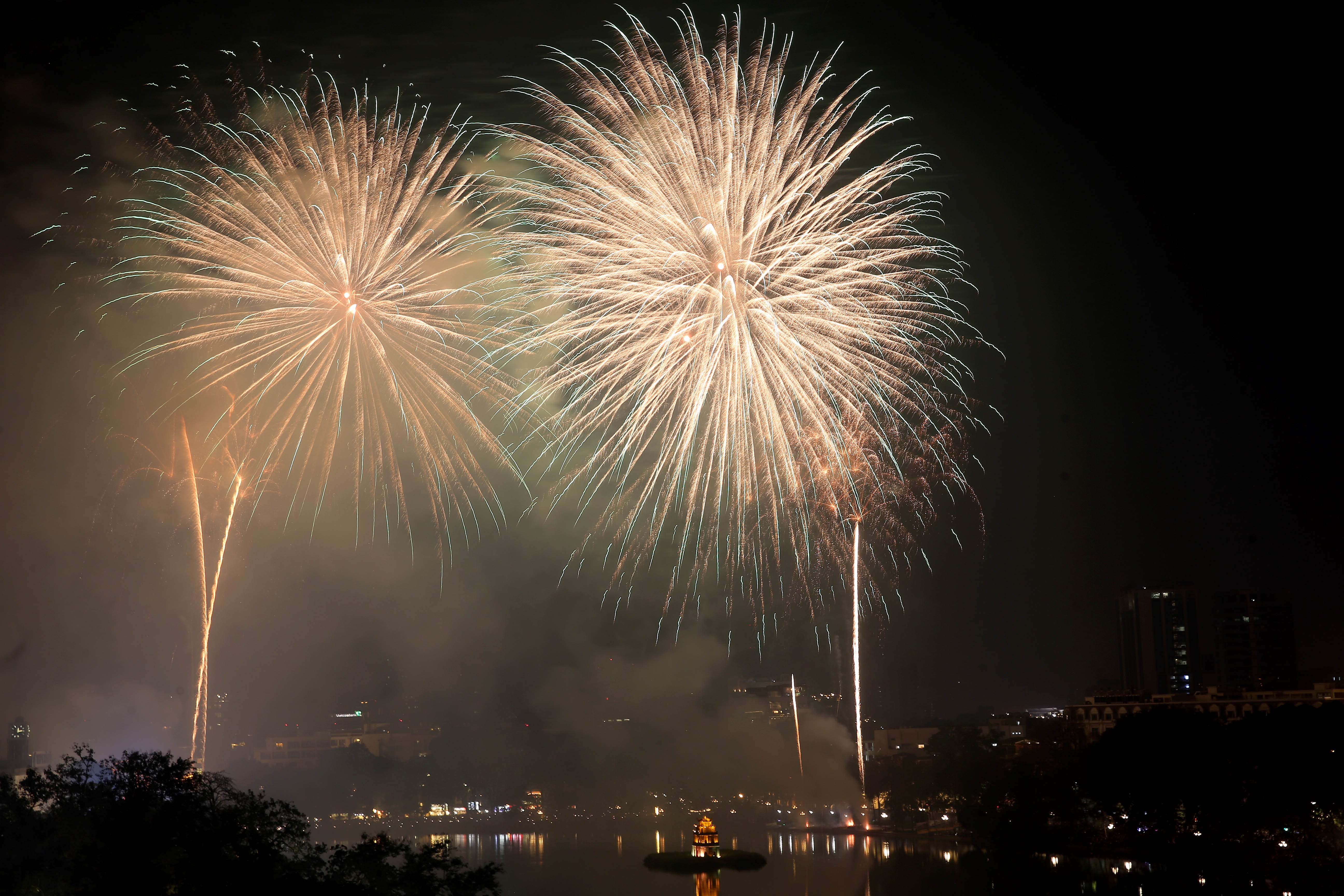 Fireworks illuminate the sky over Hoan Kiem Lake during the New Year's Eve celebrations in Hanoi, Vietnam