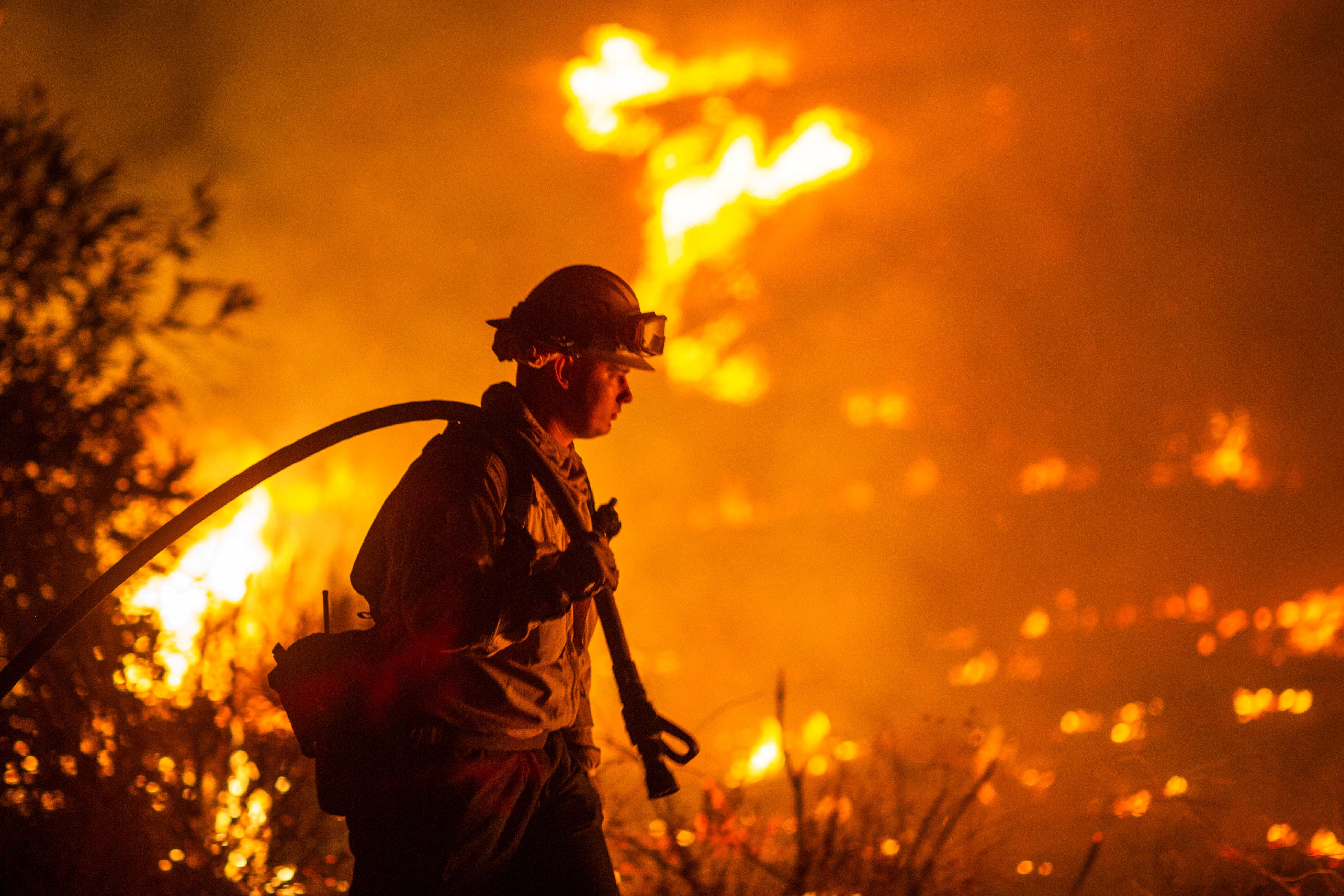 A firefighter battles the Hughes Fire near Castaic Lake, north of Santa Clarita