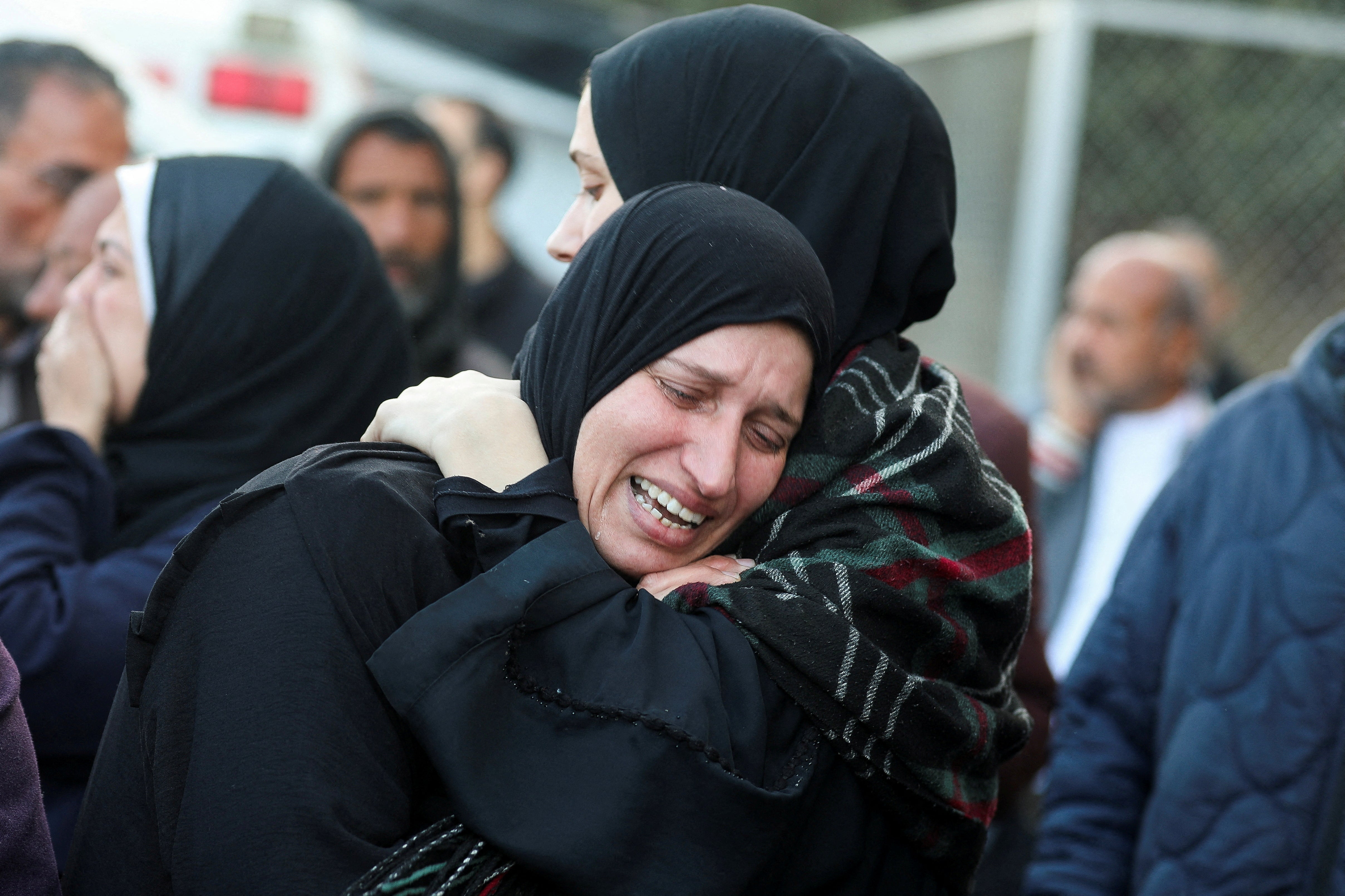 Two women mourn at Al-Aqsa Martyrs Hospital after Palestinians were killed in Israeli strikes