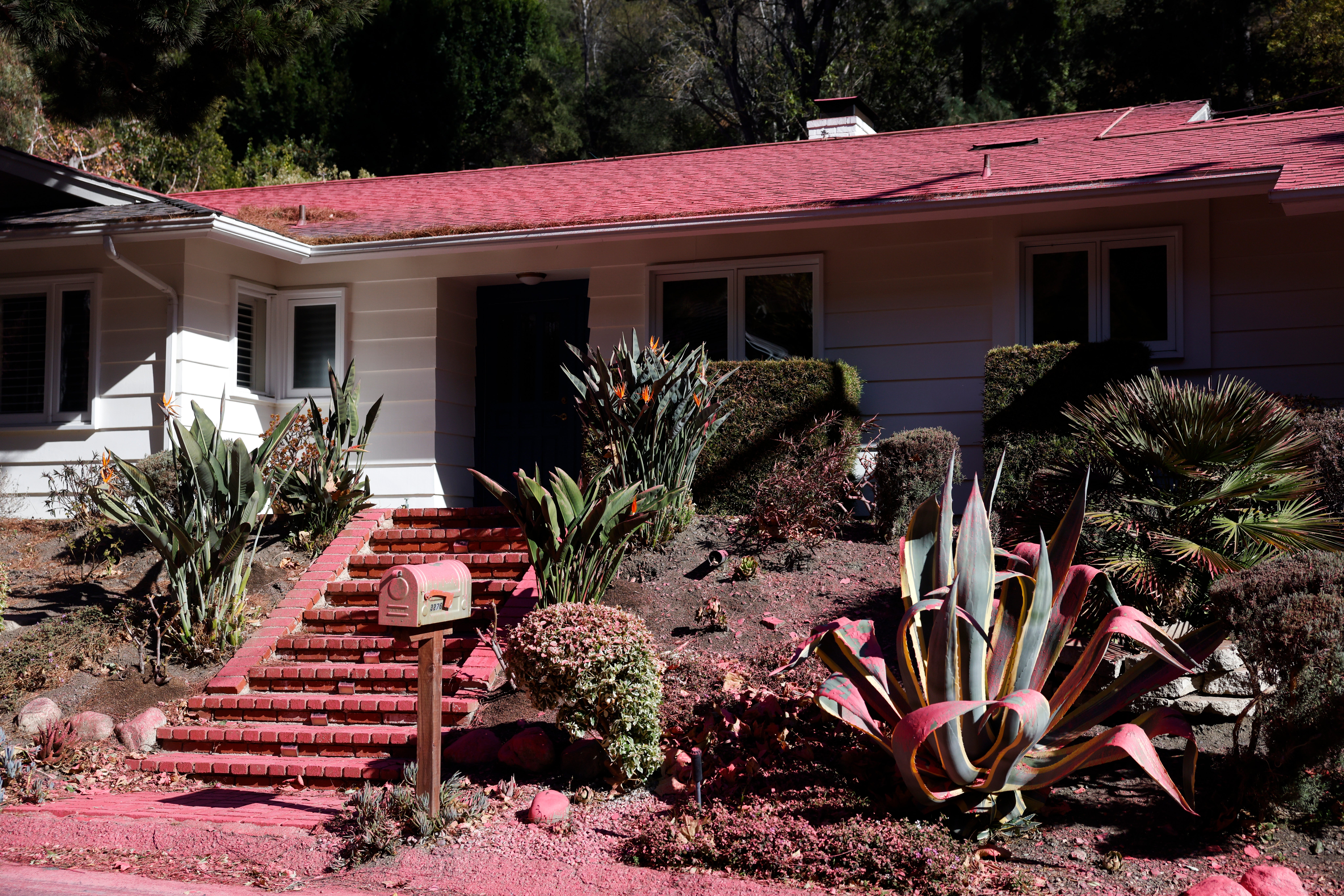 A house is covered in fire retardant in the Pacific Palisades neighborhood in Los Angeles, California, USA, 12 January 2025.