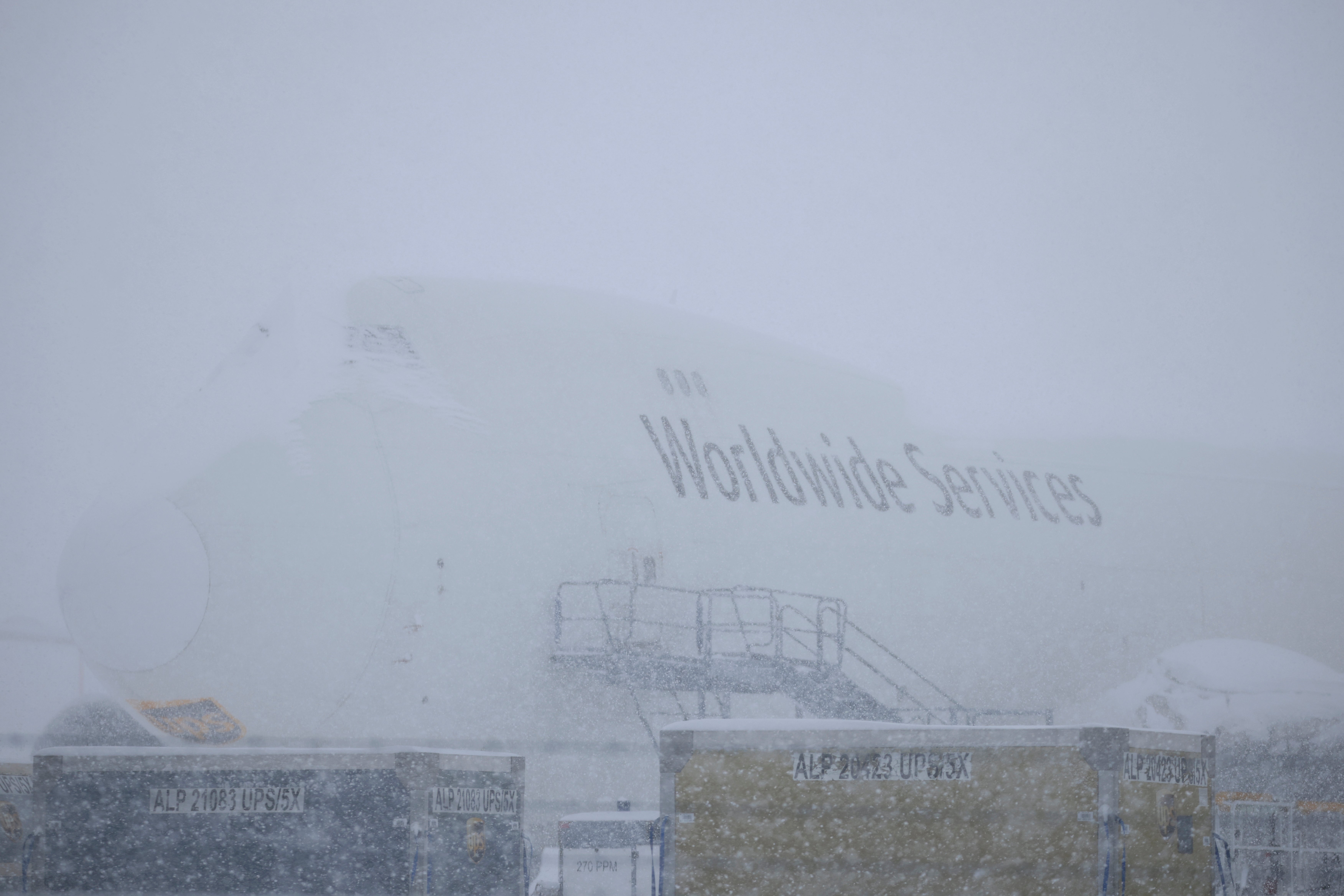 A plane sits parked during a snow storm at Louisville Muhammad Ali International Airport in Louisville, Kentucky on Sunday