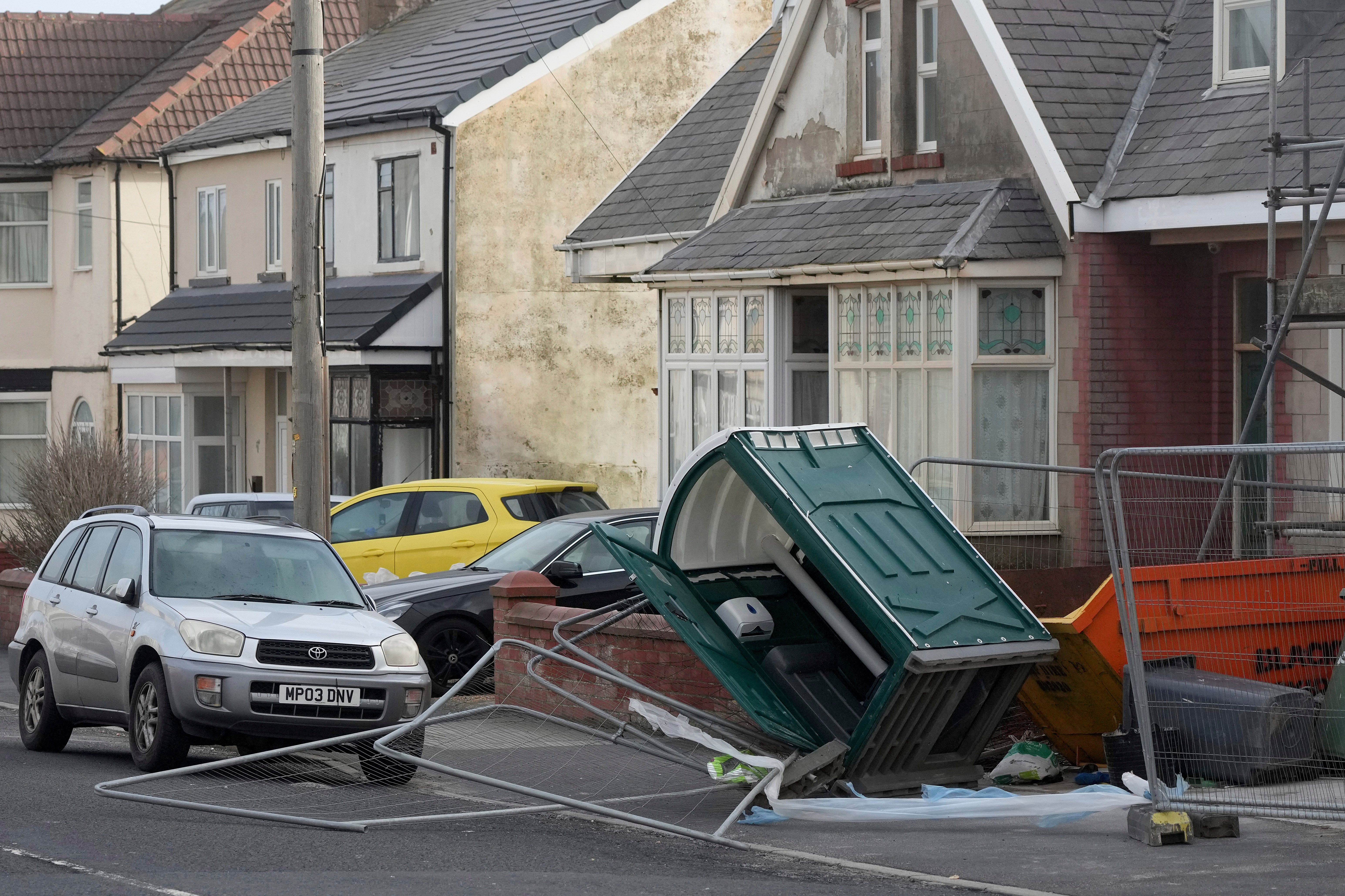 A fence and a mobile toilet blown over by the wind as Storm Eowyn hits the country in Blackpool, England