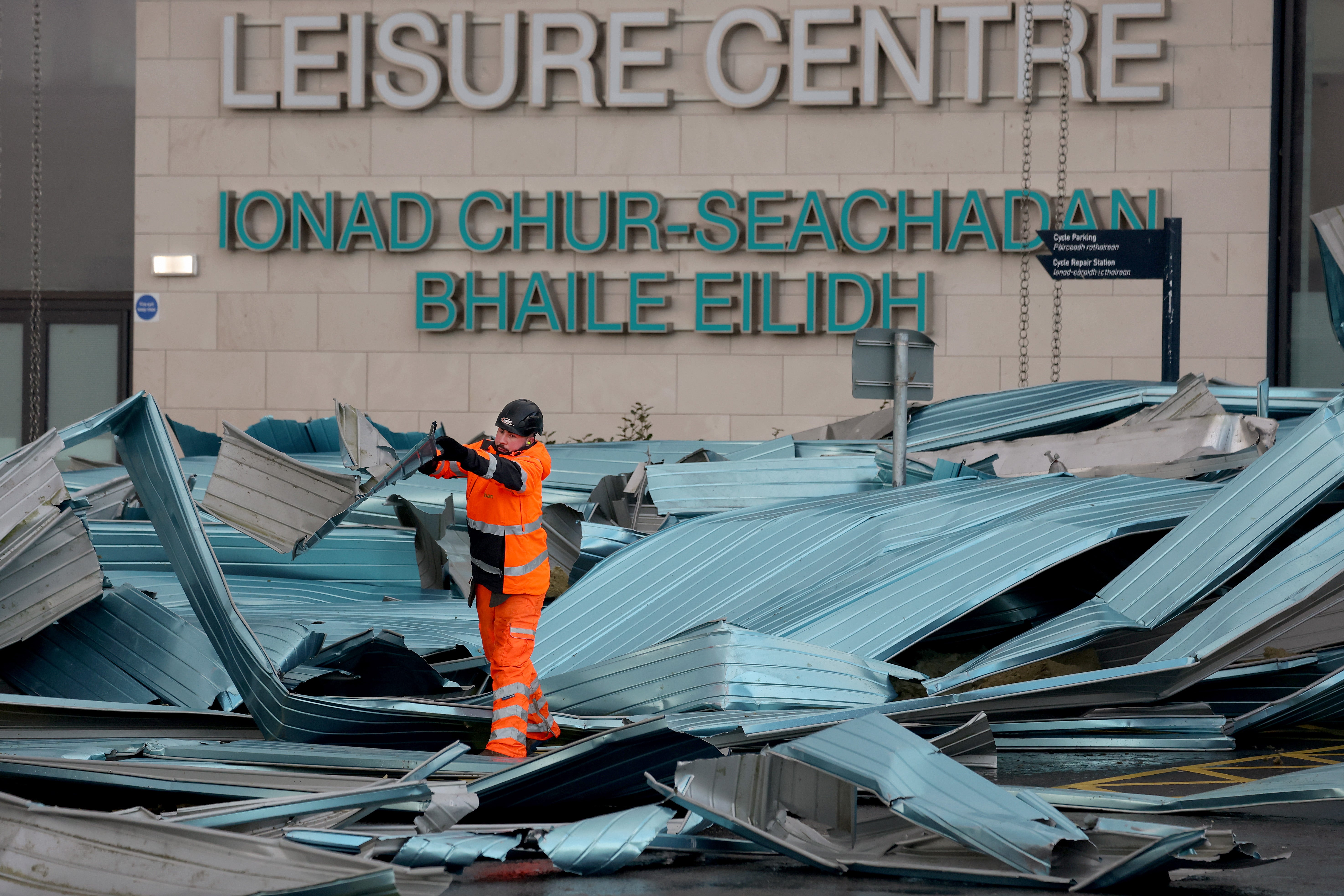 Workers clear debris from the roof blown off a leisure centre during storm Eowyn in Helensburgh, Scotland