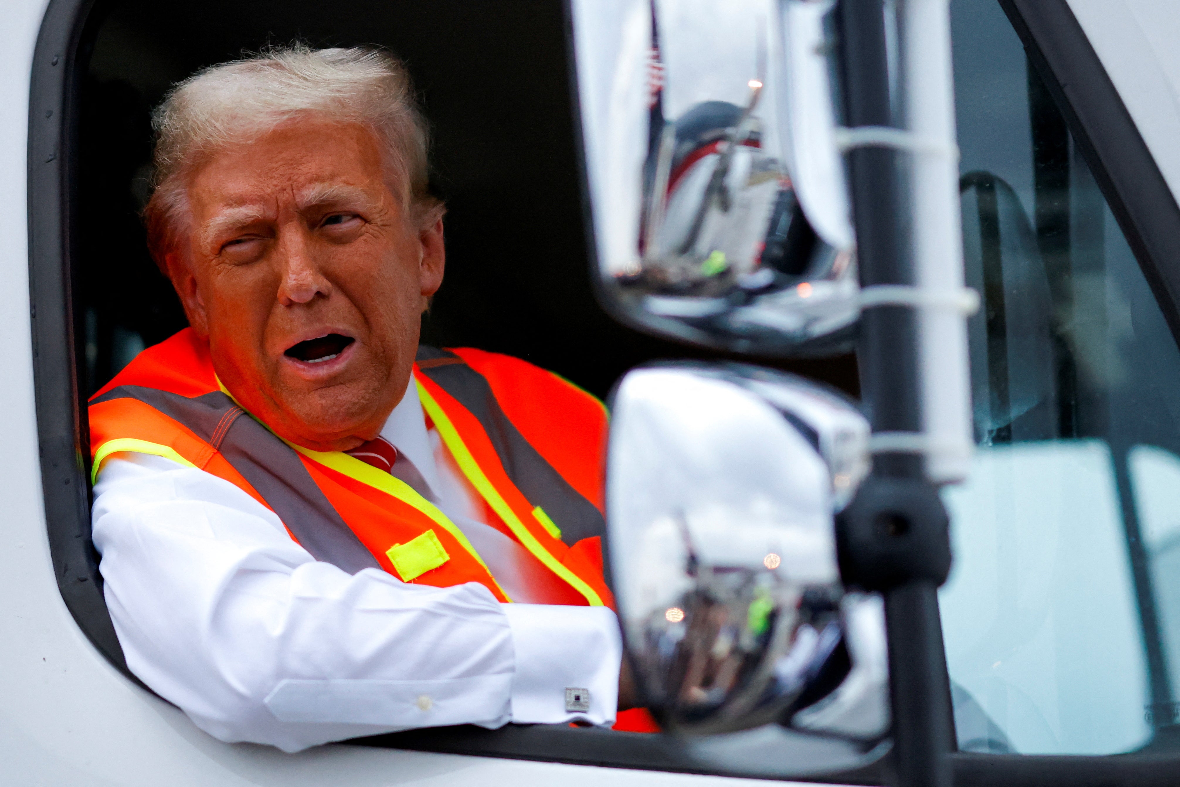 Trump reacts as he sits in a garbage truck, in Green Bay, Wisconsin, on October 30