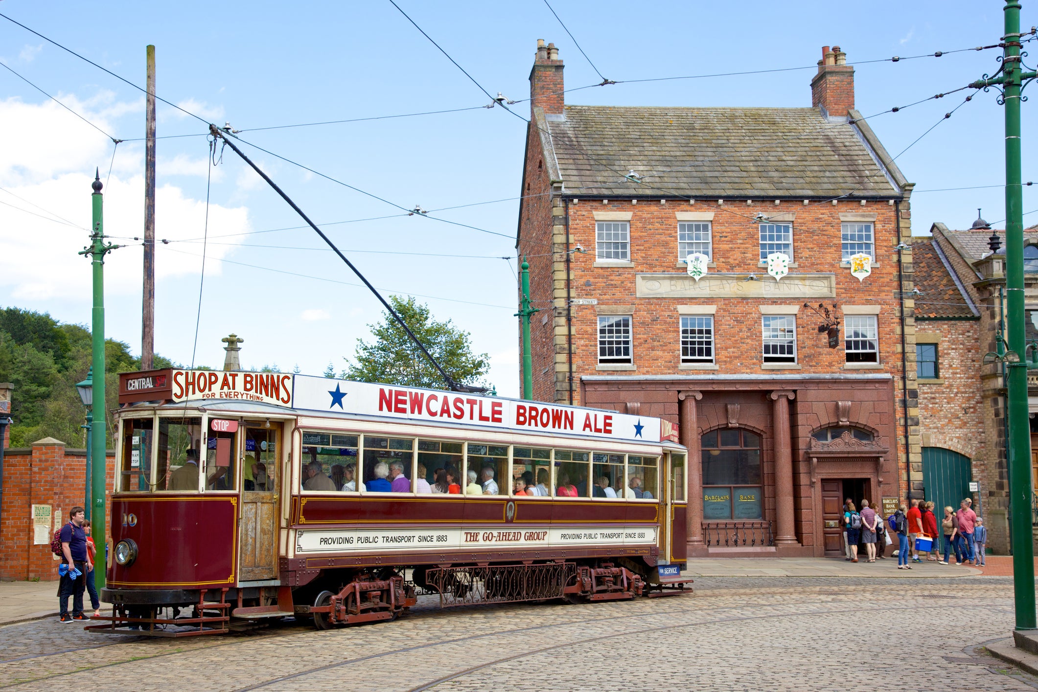 A tram and tourists in the high street of the Edwardian town that forms part of Beamish Museum in County Durham, England