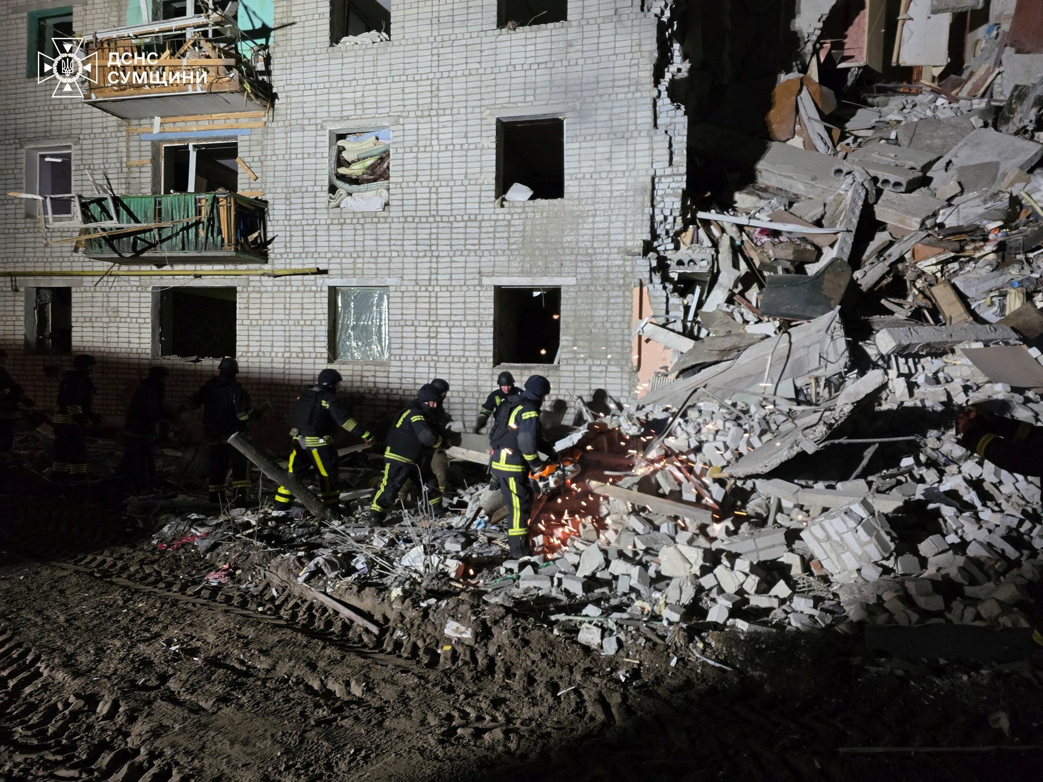 Rescuers work at the site of a residential building hit by a Russian air strike in the village of Svesa, in Ukraine’s Sumy region